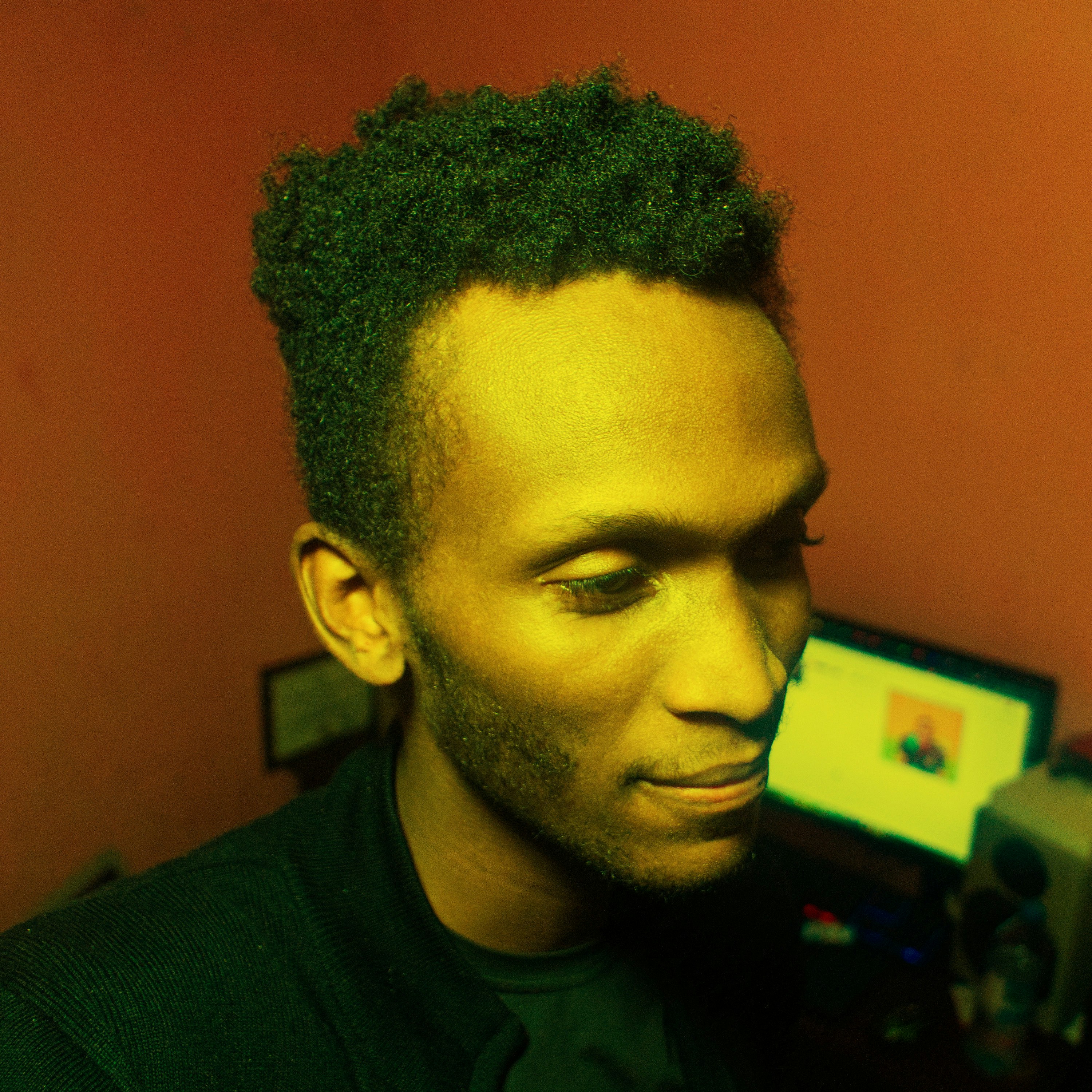 A man in a black shirt is looking at a computer screen