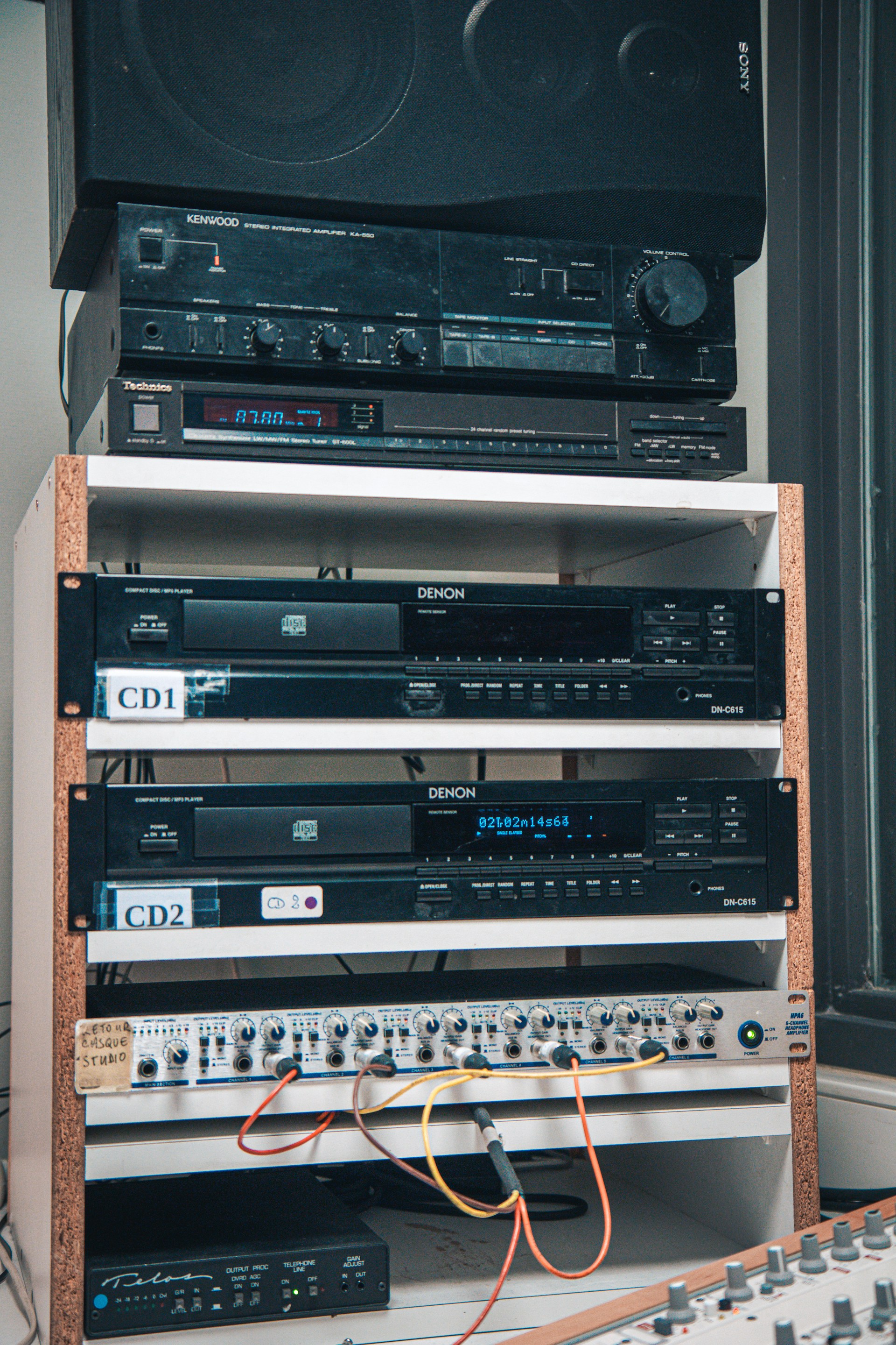 A stack of stereo equipment sitting next to a window