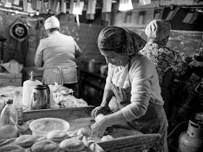 A black and white photo of a woman in a kitchen
