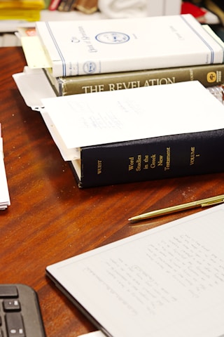 A desk with three books and a calculator