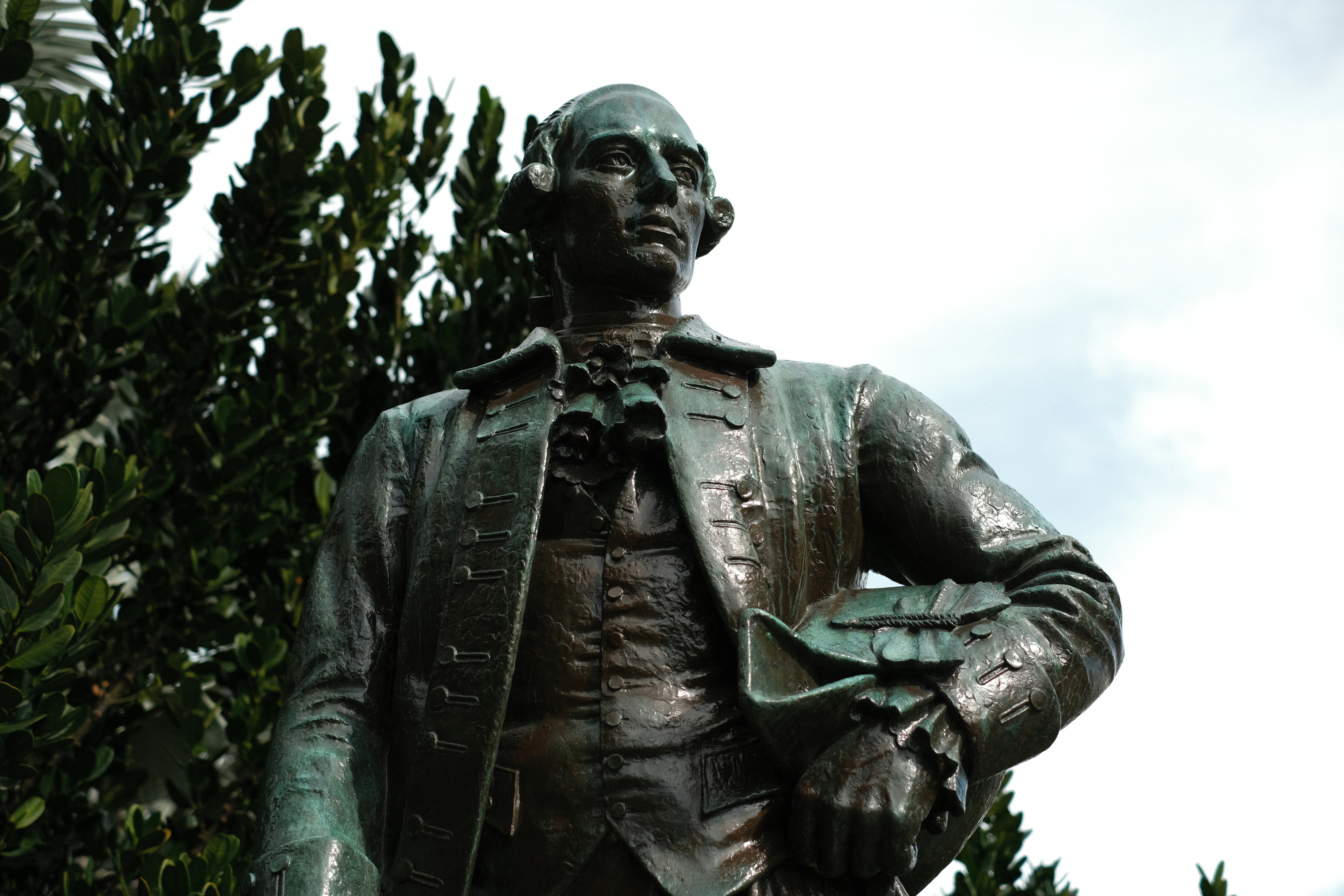 A statue of a man holding a book in his hands