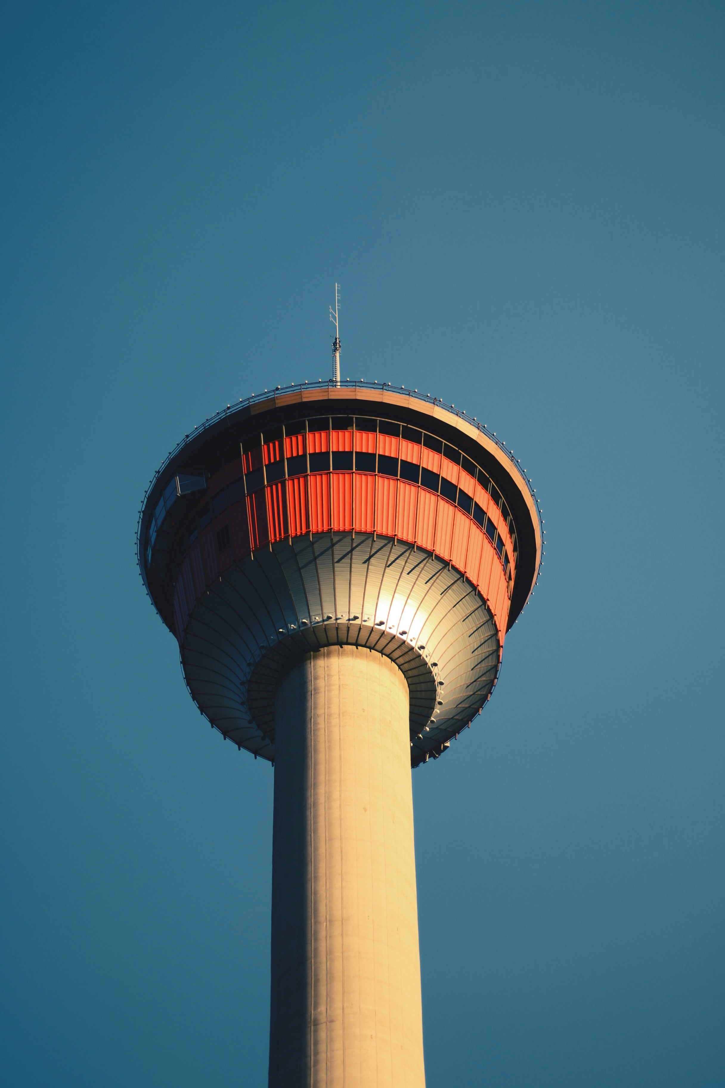 A tall tower with a red top against a blue sky
