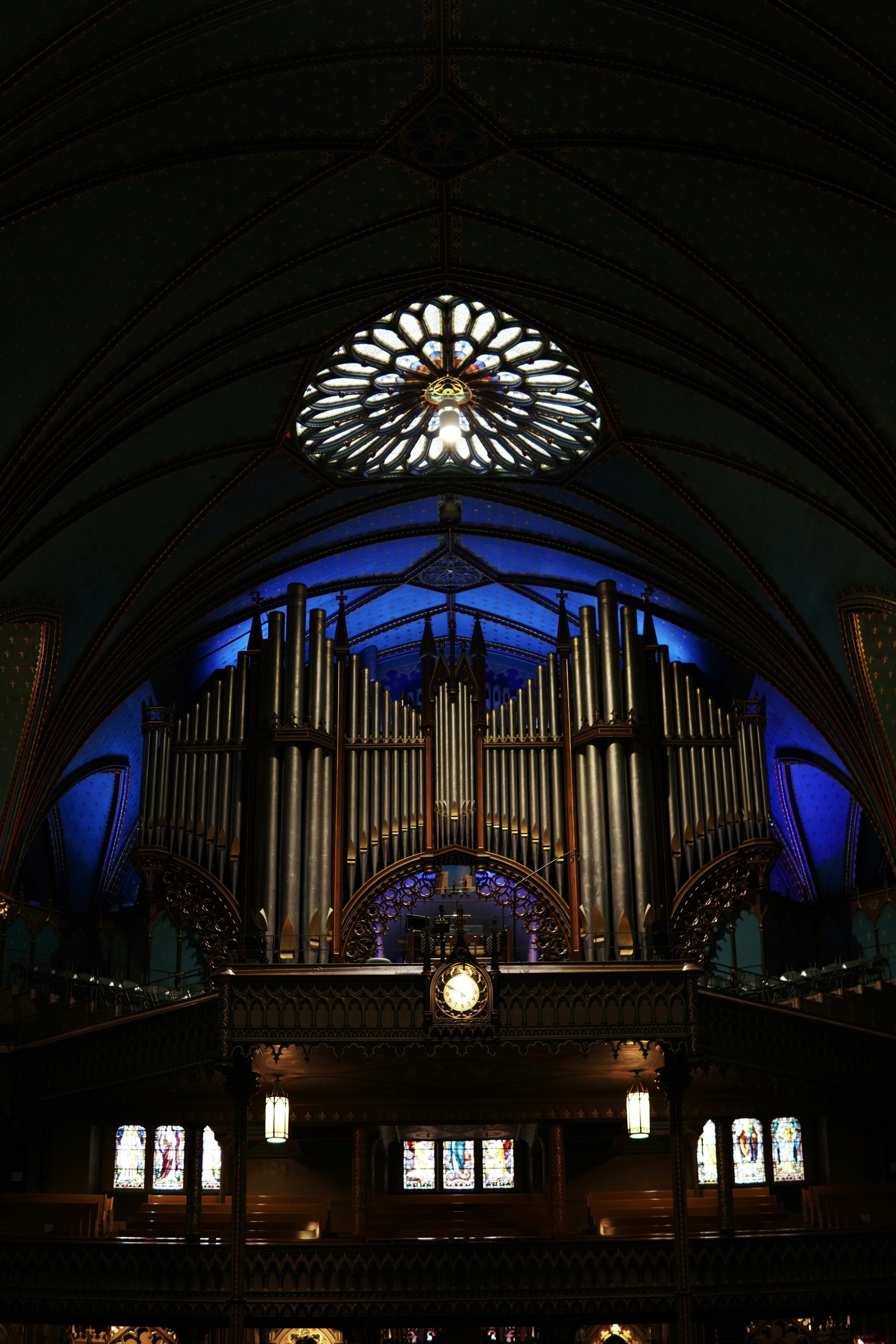 A large pipe organ in a church with stained glass windows