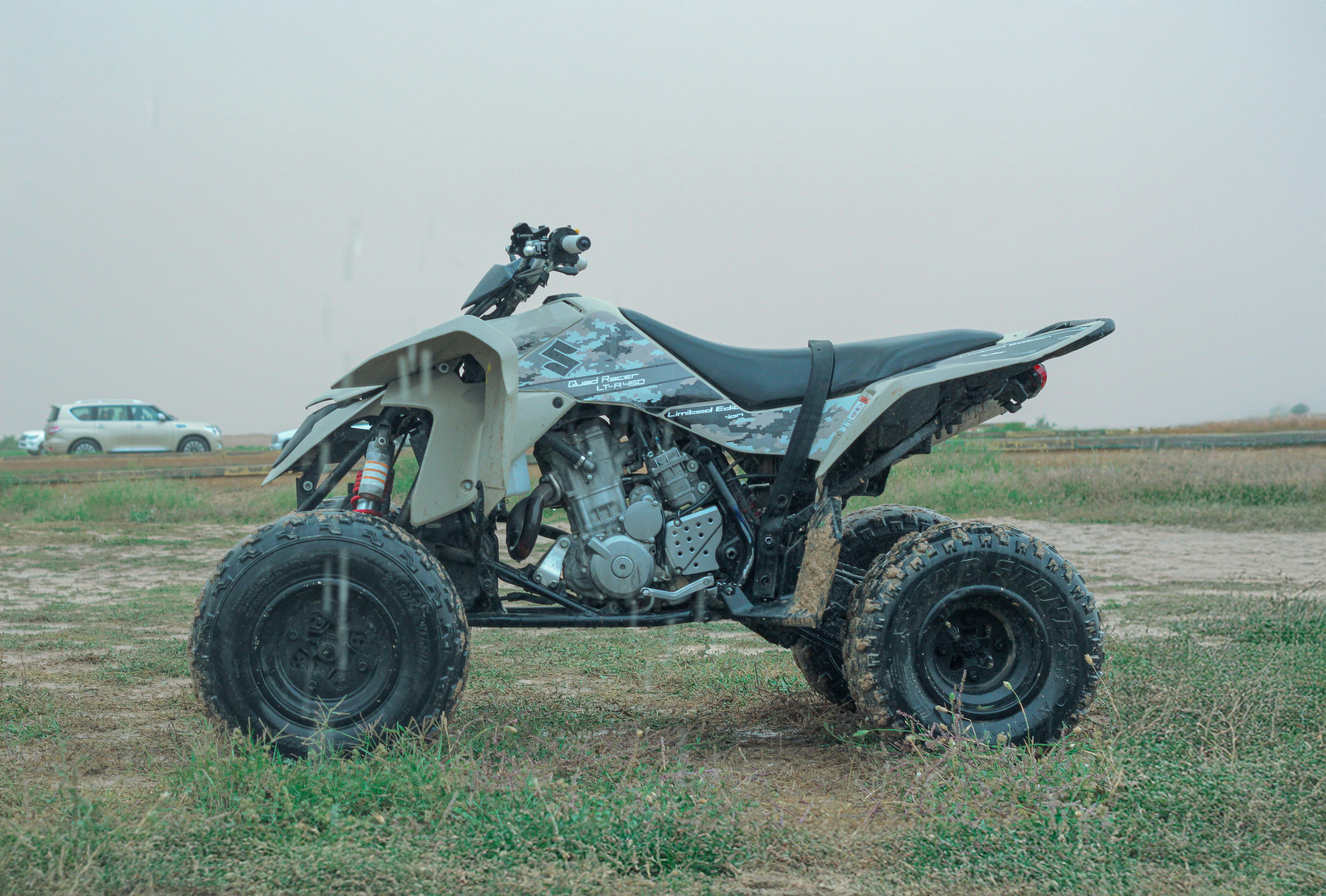A white four - wheeler parked in a grassy field