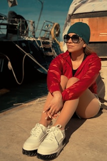 A woman sitting on the ground next to a boat
