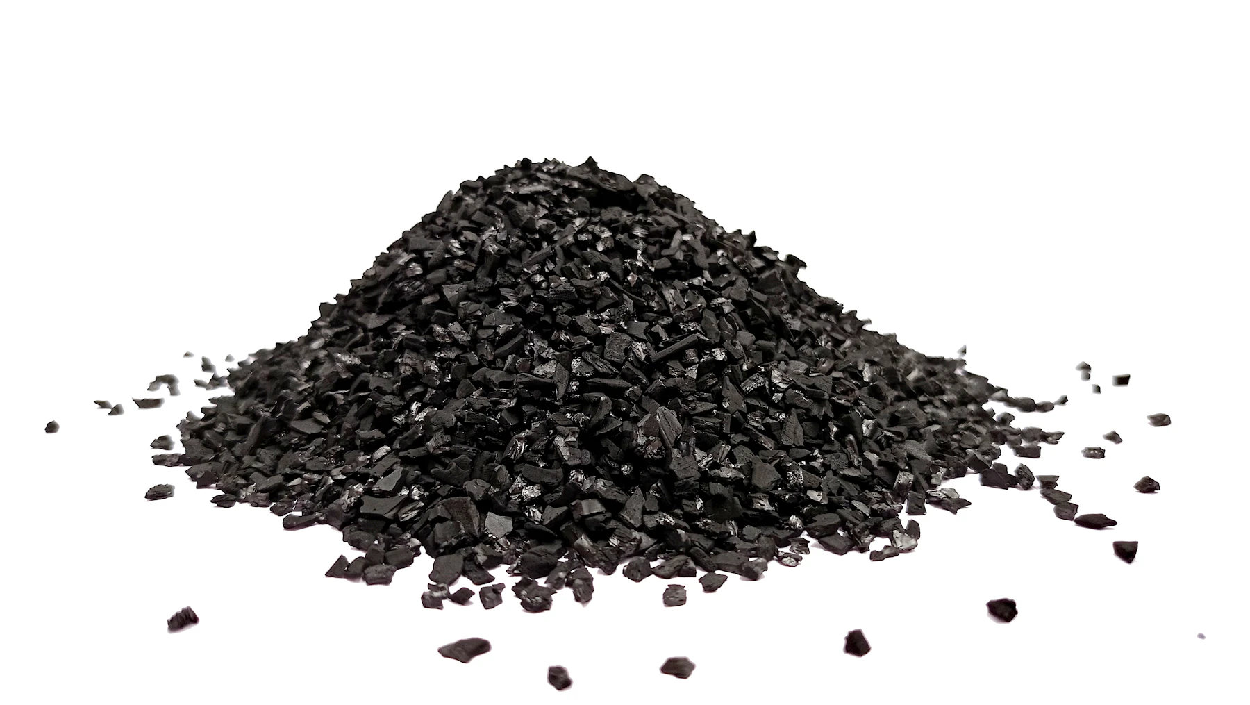 A small cone-shaped pile of crushed black char granules on a white surface, with loose pieces scattered around it