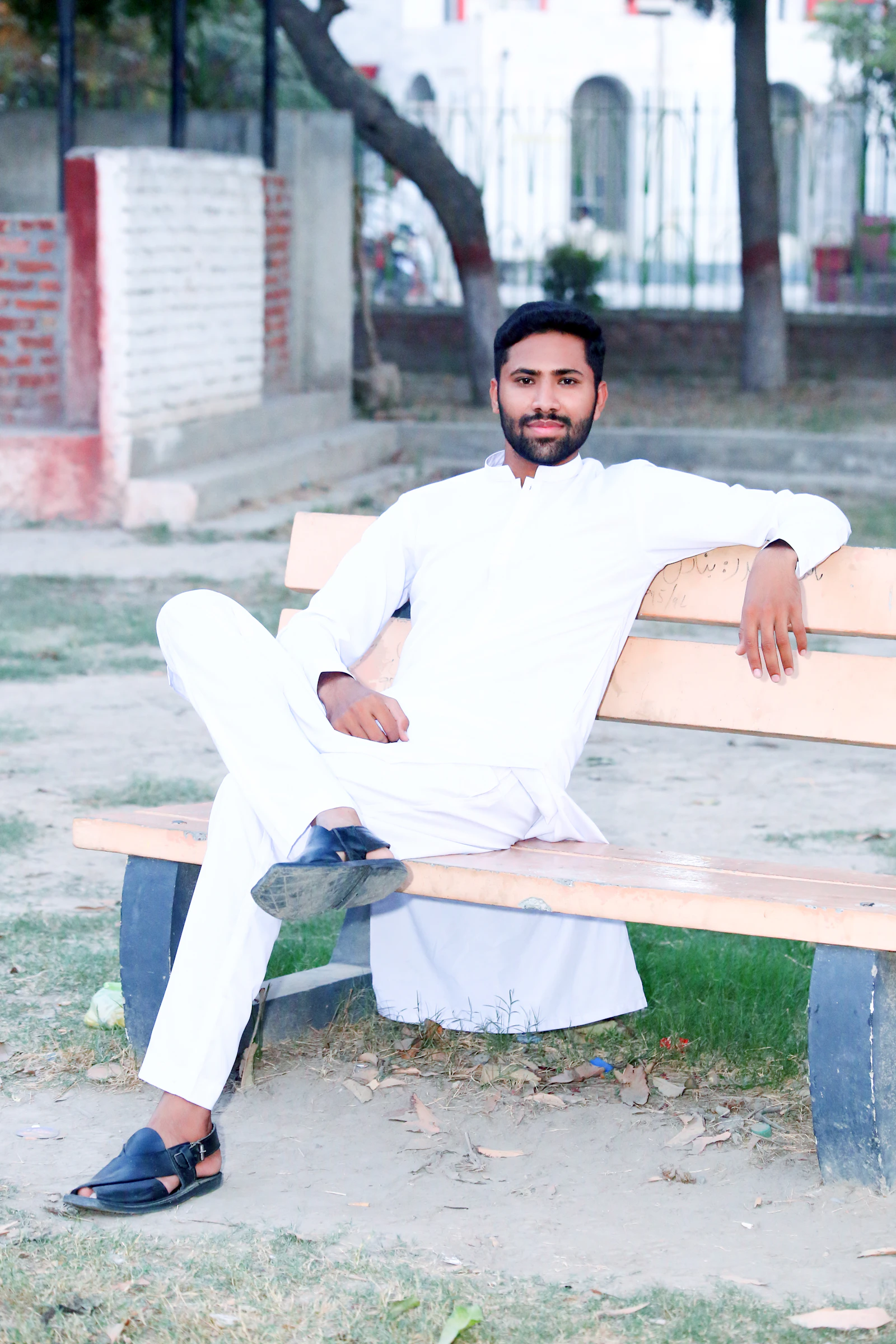 Man in white shalwar kameez on bench