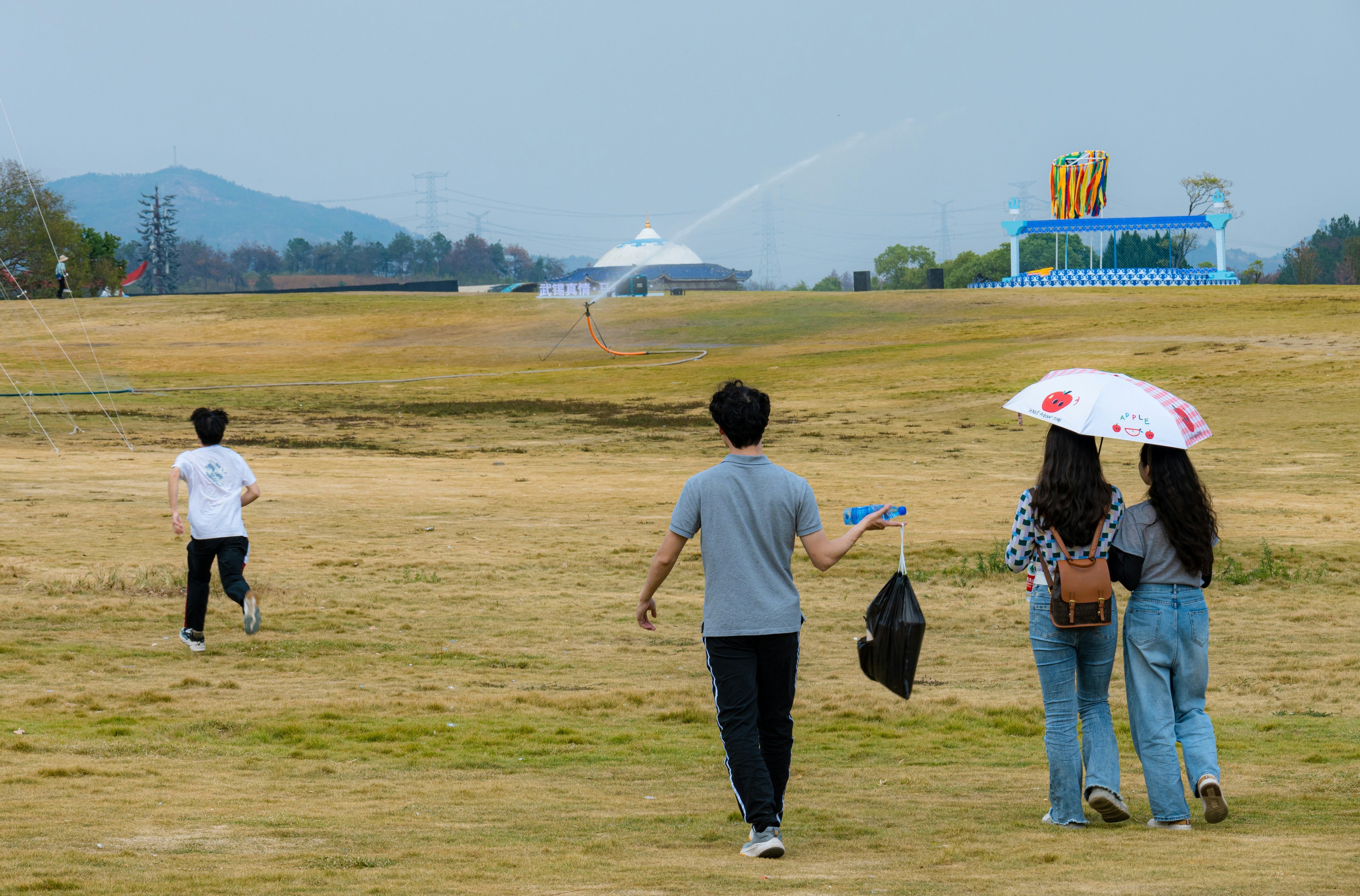A group of people standing on top of a grass covered field