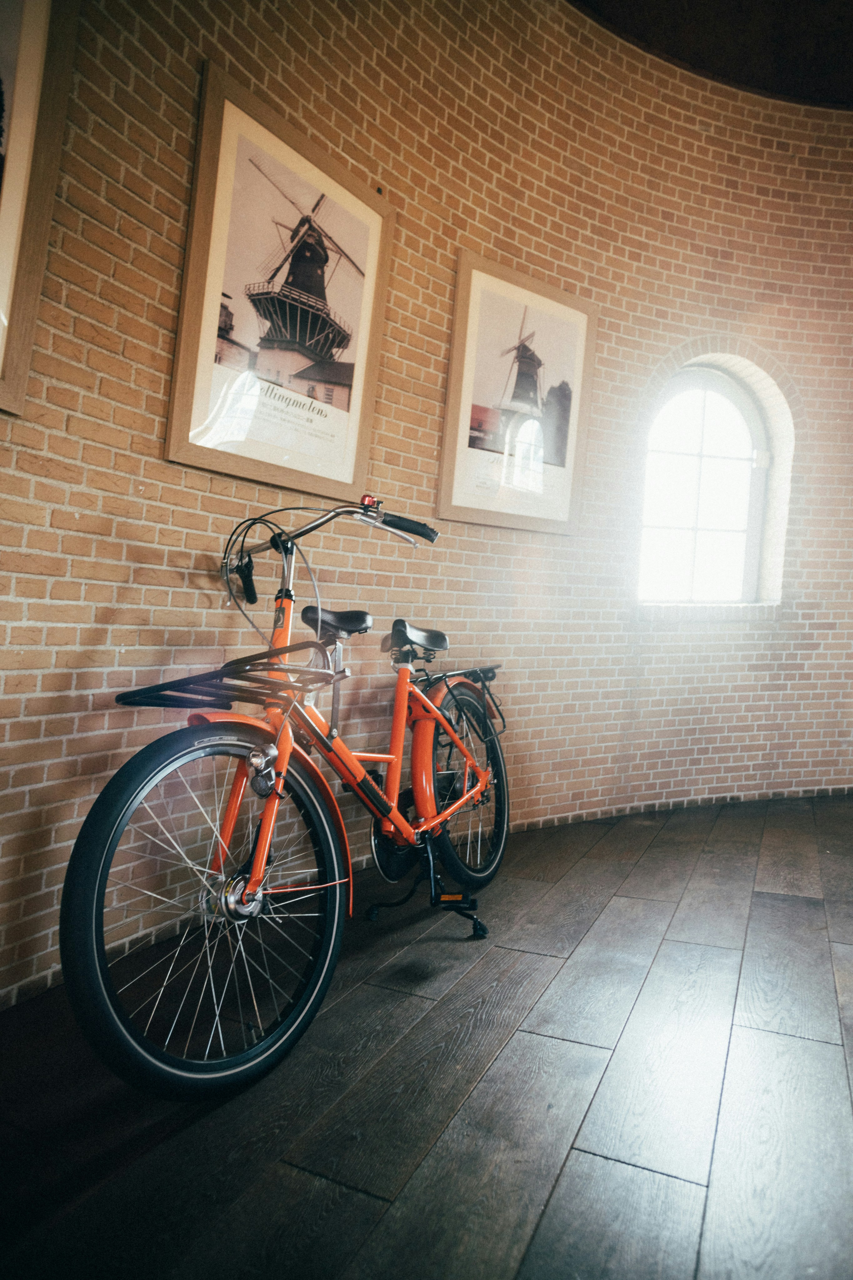 A bike is parked against a brick wall