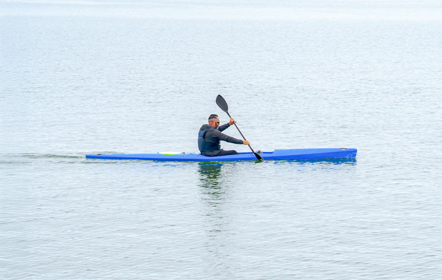 Person paddling a kayak across calm open water on a clear day