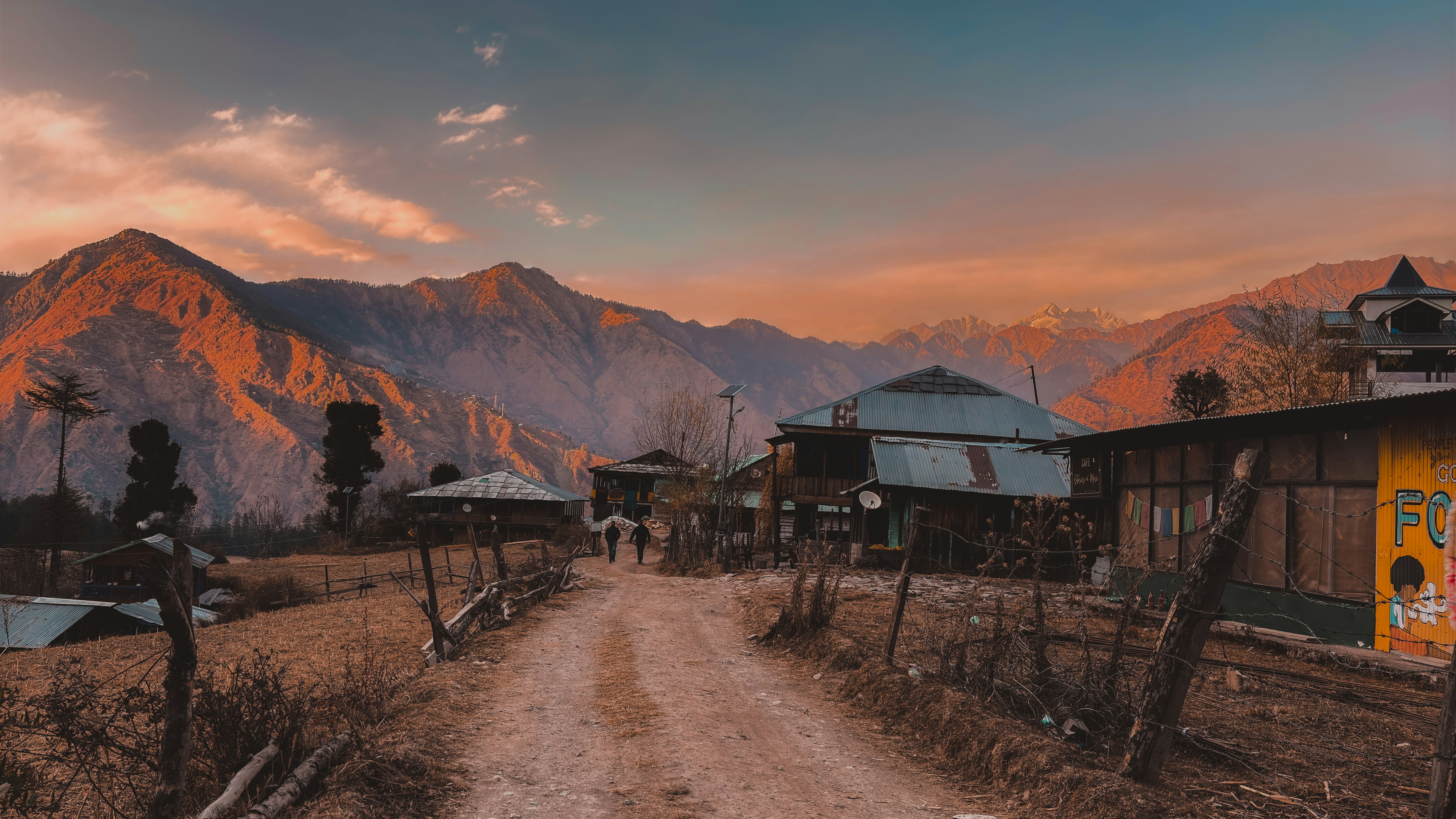 A dirt road in front of a mountain range
