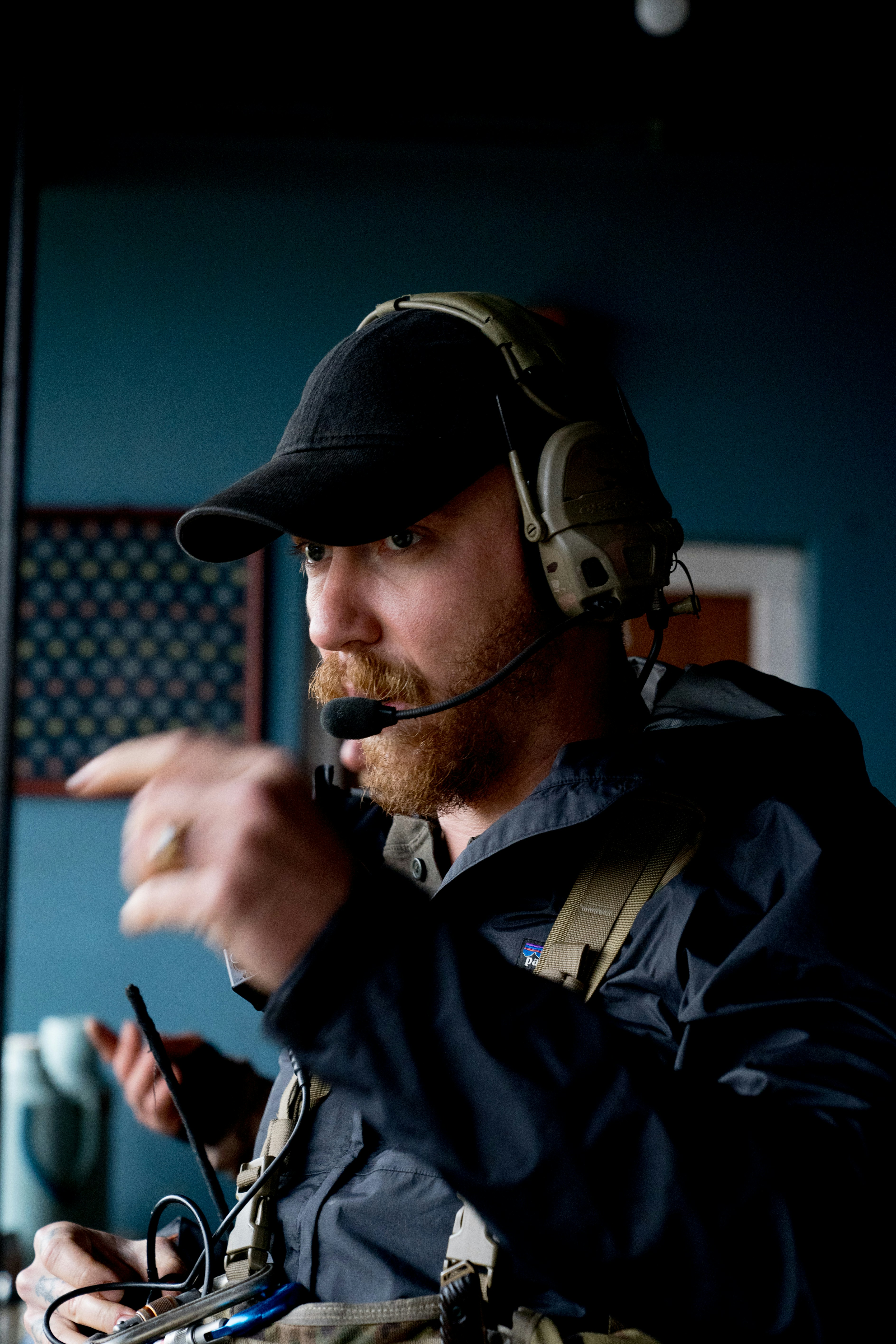 A man in a black hat is pointing at something