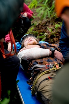 A man with a cast on his arm laying on a blue tarp