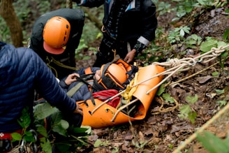 A man in an orange life jacket is being assisted by a rescue worker
