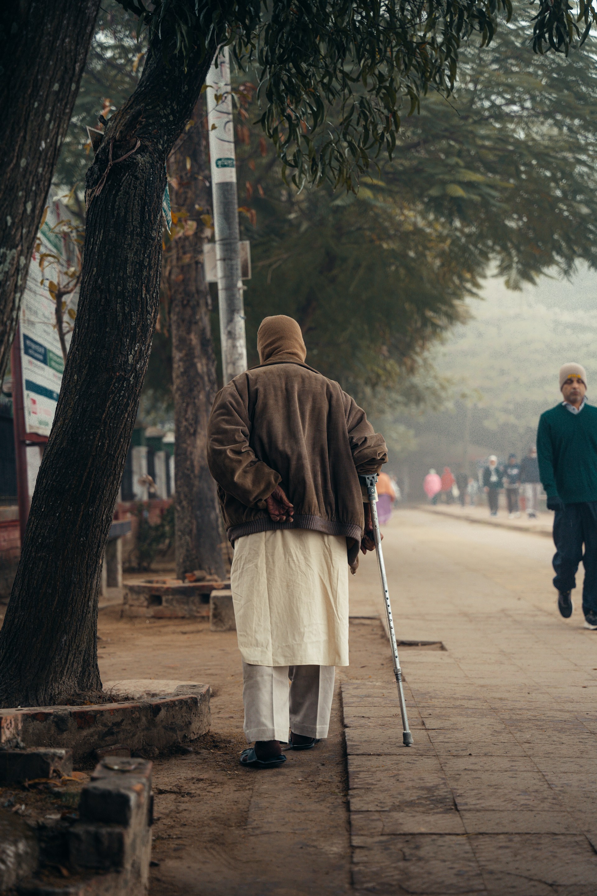 A person walking down a street with a cane