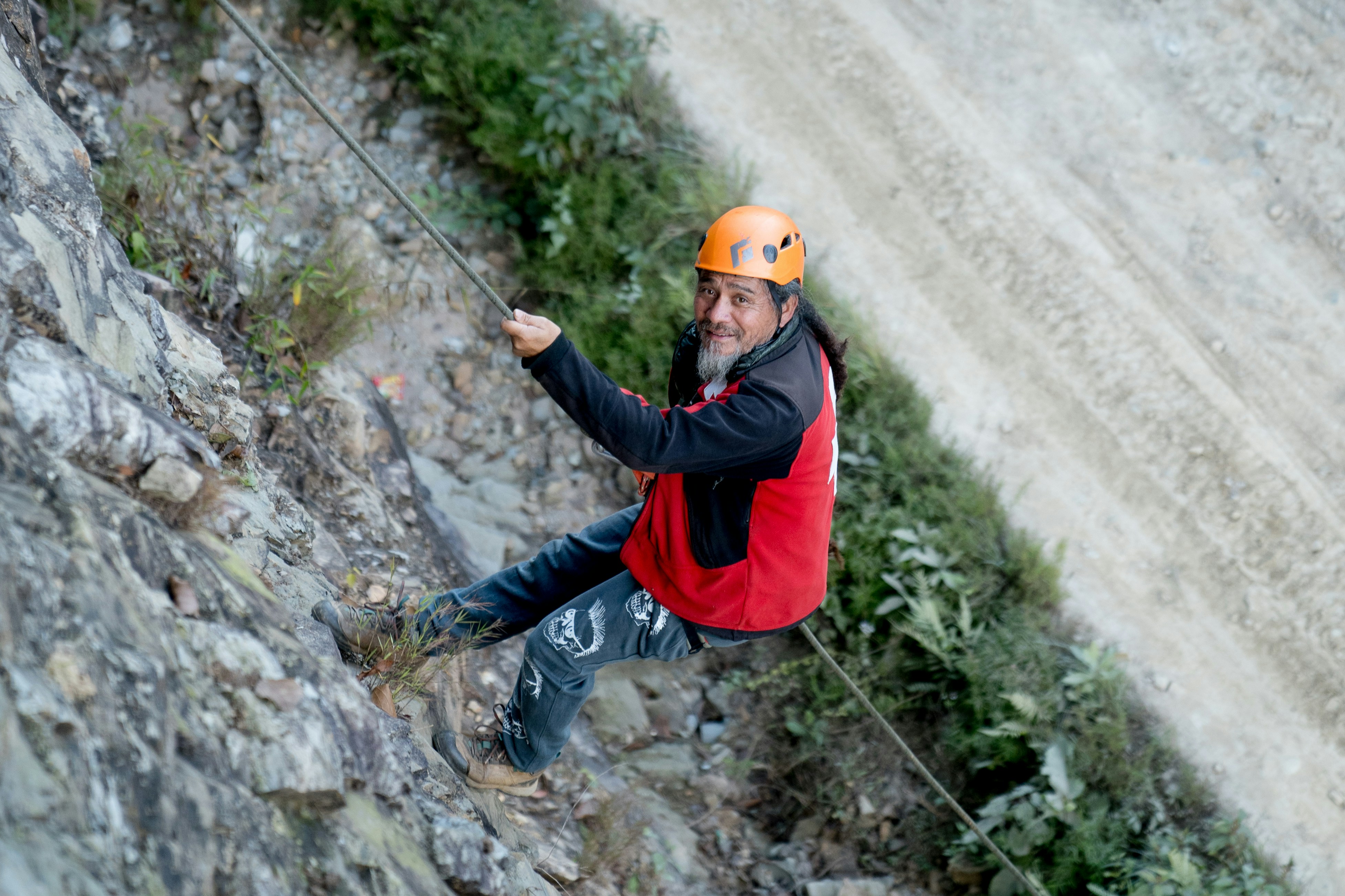 A man rock climbing up the side of a mountain