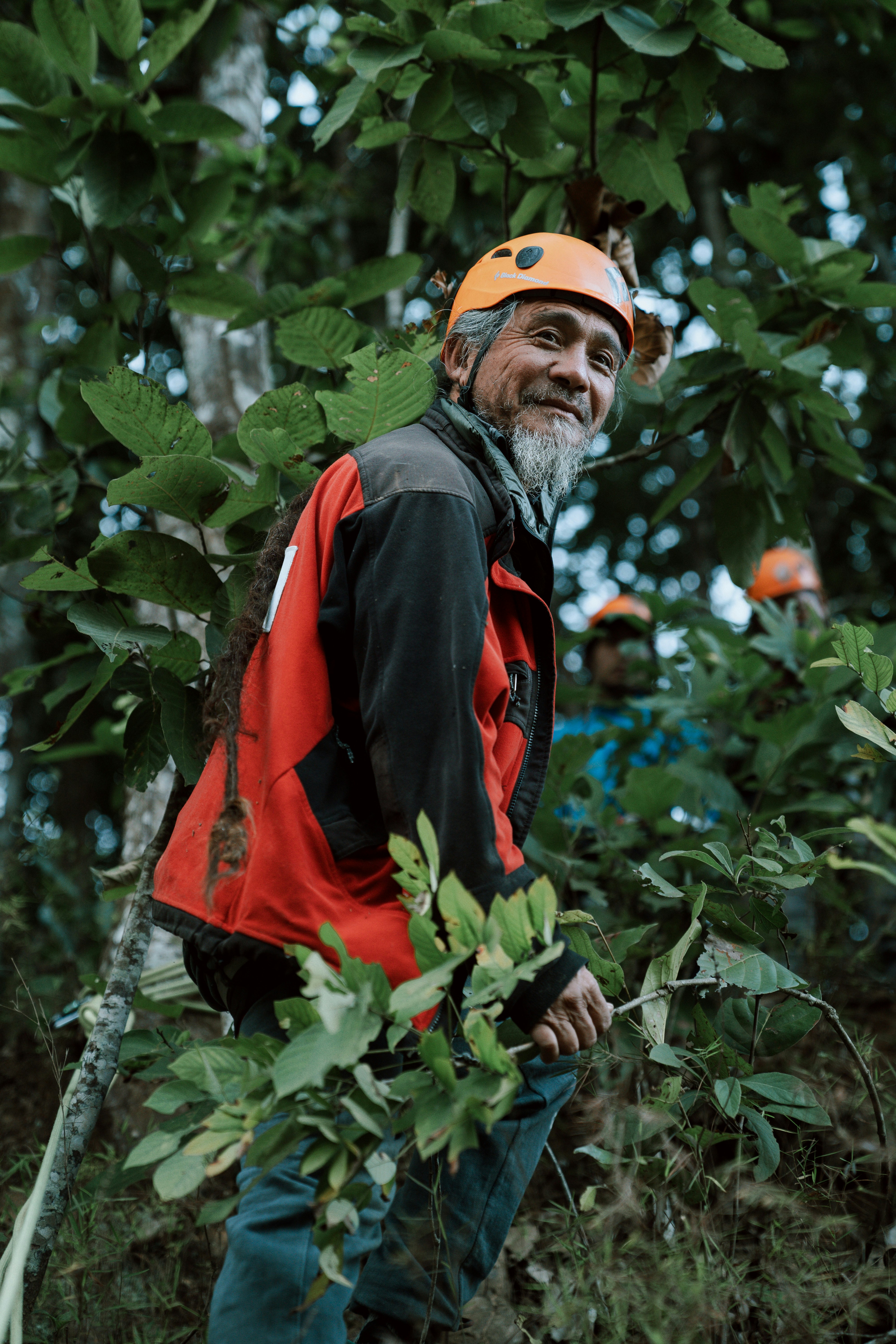 A man with a helmet standing in the woods