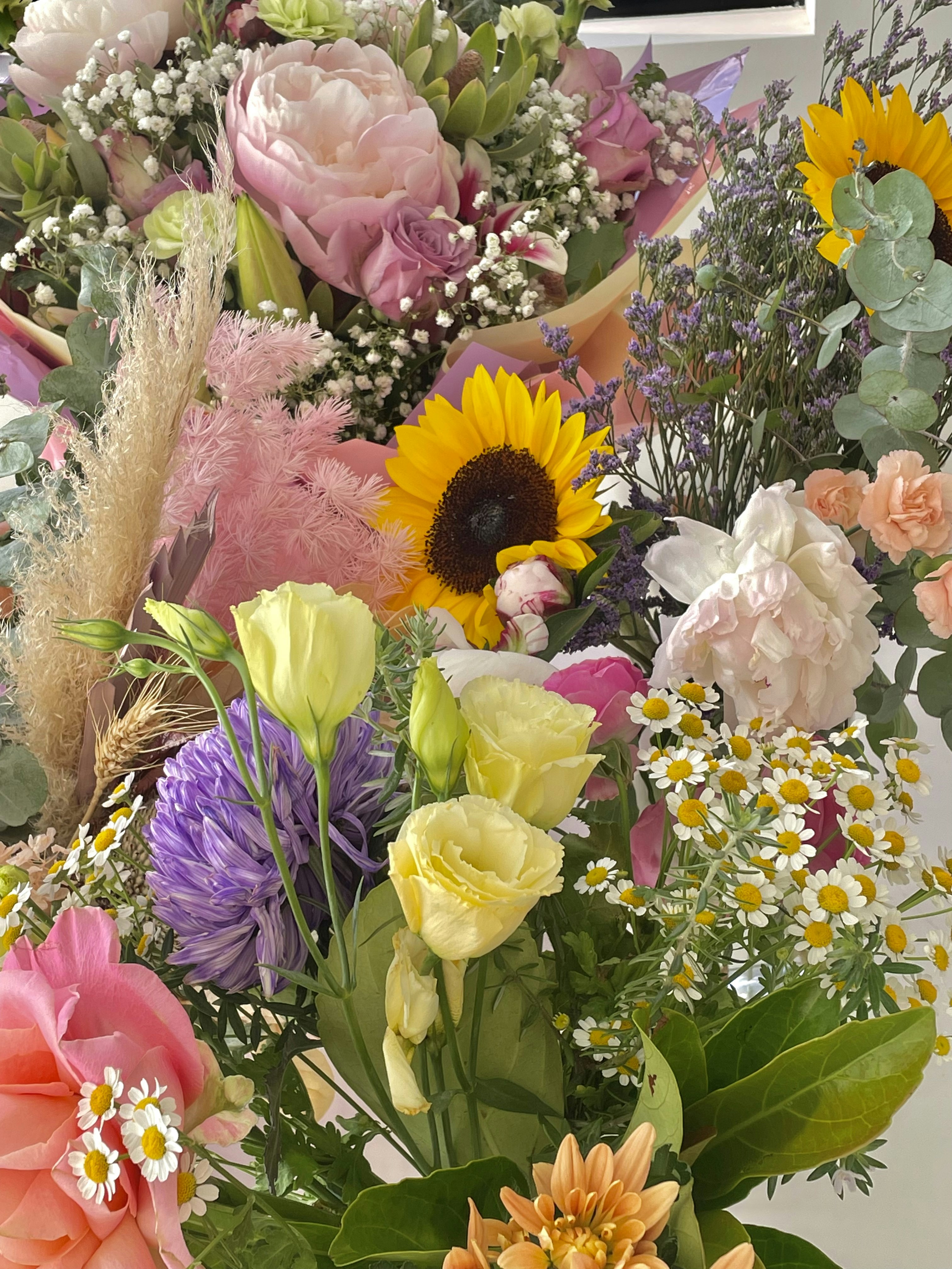 Vibrant seasonal mixed bouquet with sunflowers, dahlias and wildflowers in warm light
