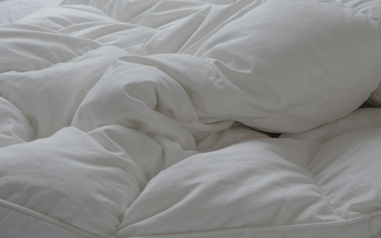 A fresh white comforter on a bed
