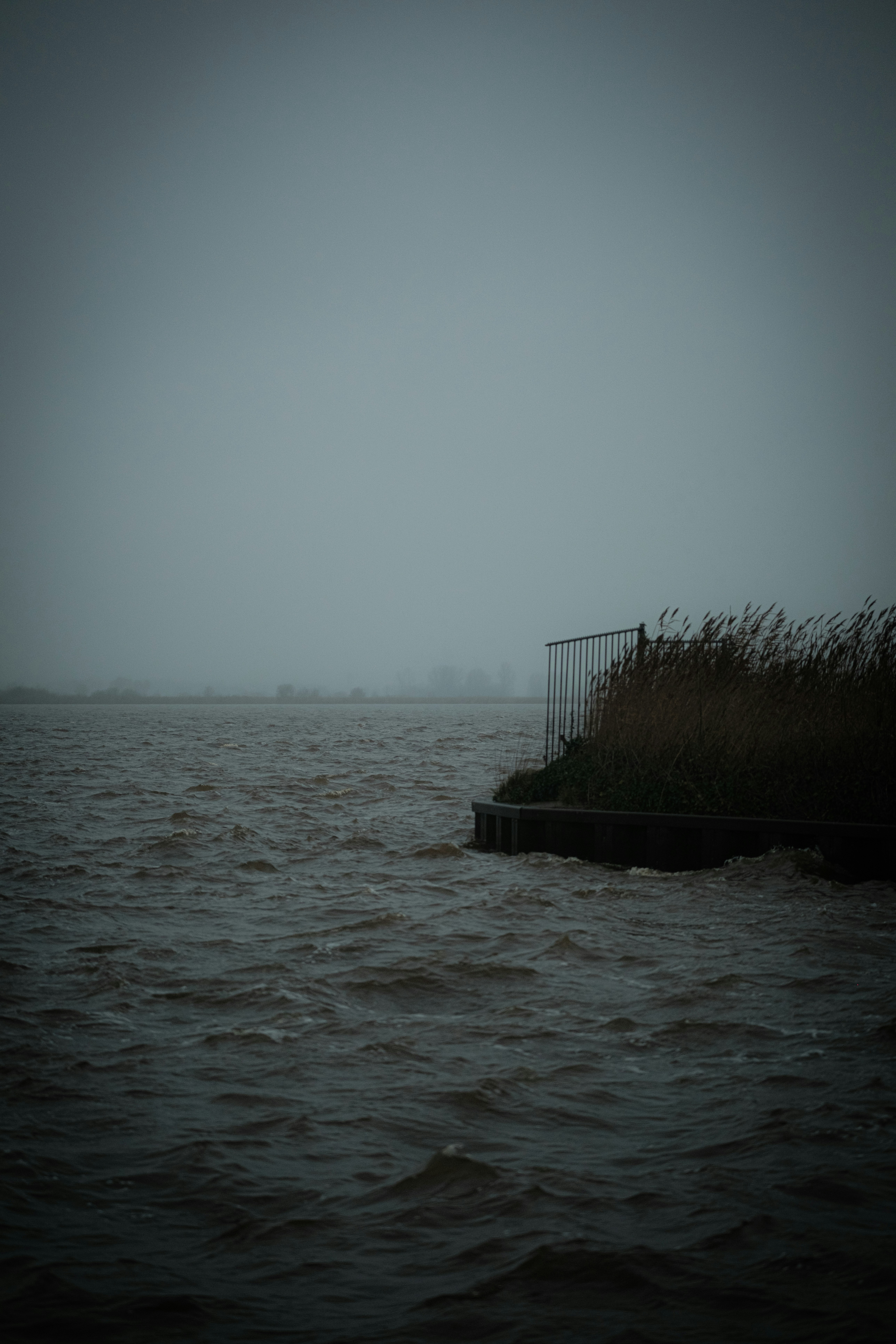 Un plan d’eau avec une clôture au milieu de celui-ci