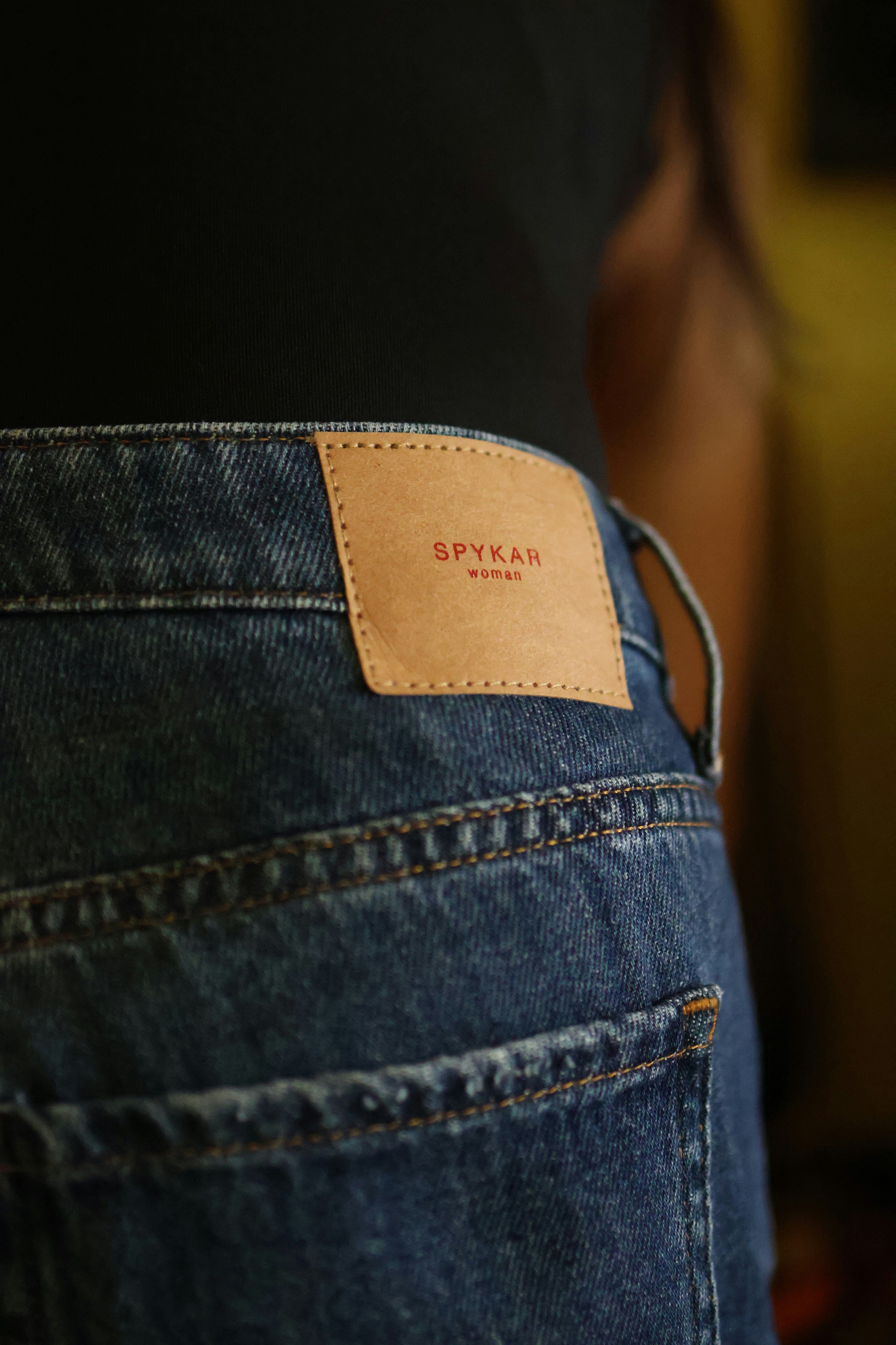 A person wearing a pair of jeans with a label on their back pocket