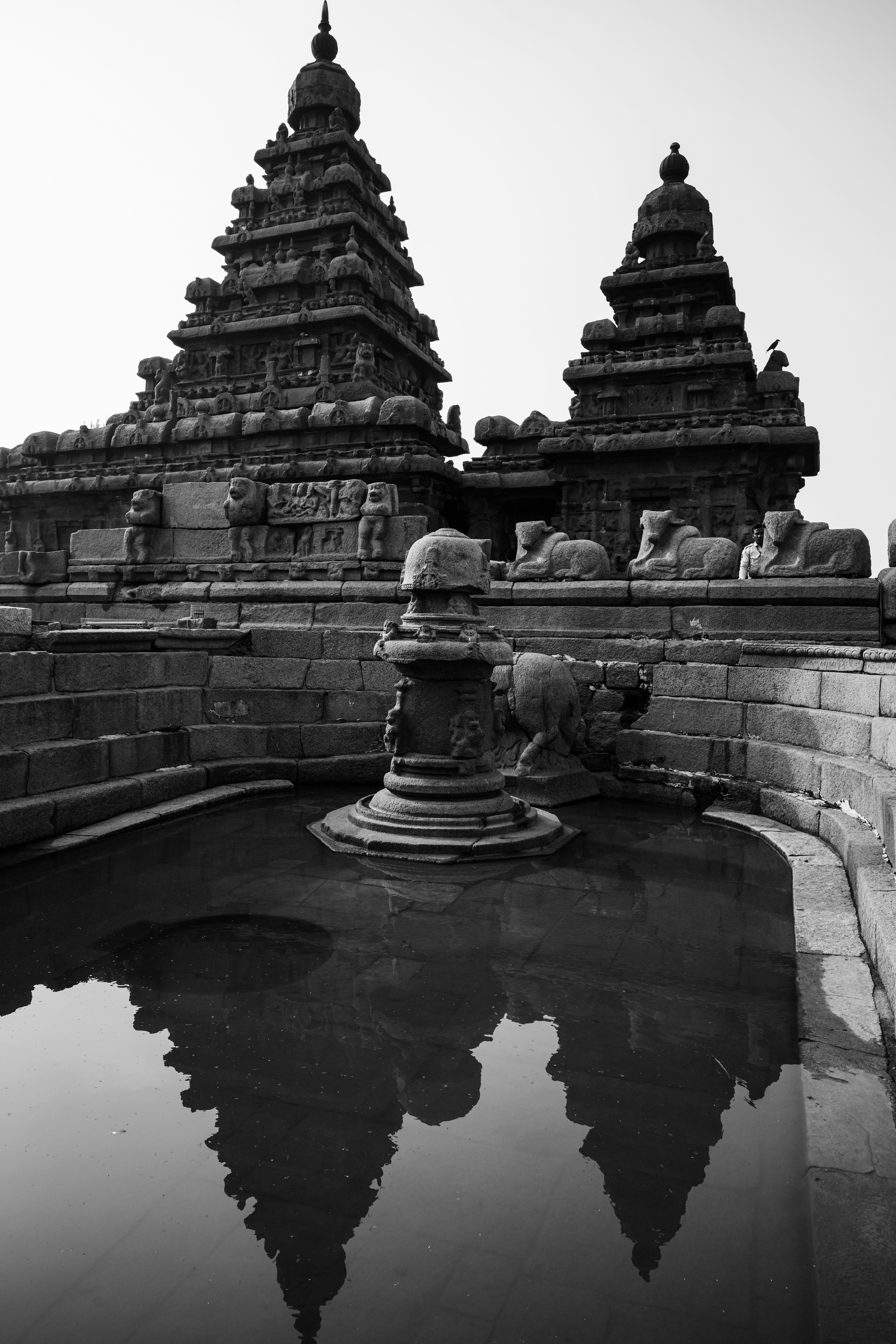 Ancient temple with golden spires reflected in a calm water pool