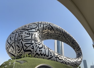 A large sculpture of a giant snake in front of a building