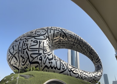 A large sculpture of a giant snake in front of a building