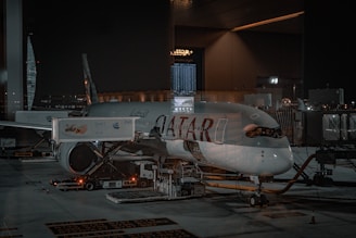 An airplane is parked on the tarmac at night