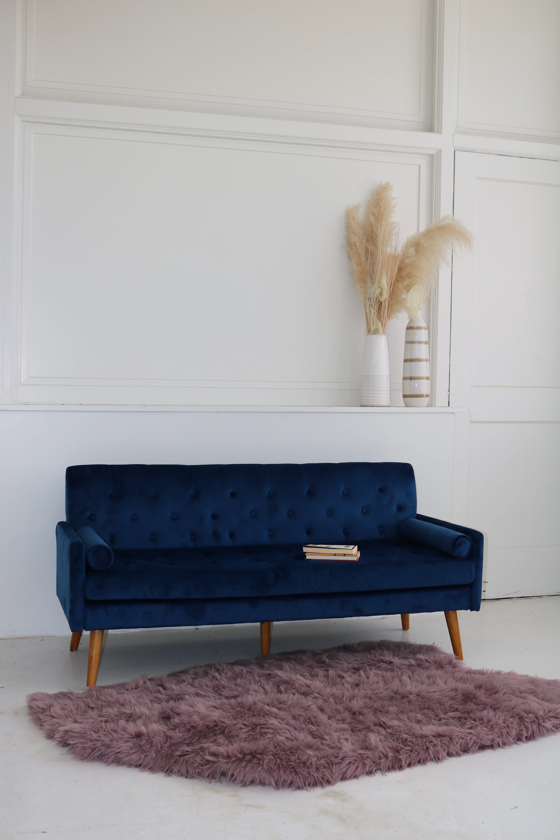 A living room with a blue couch and a rug