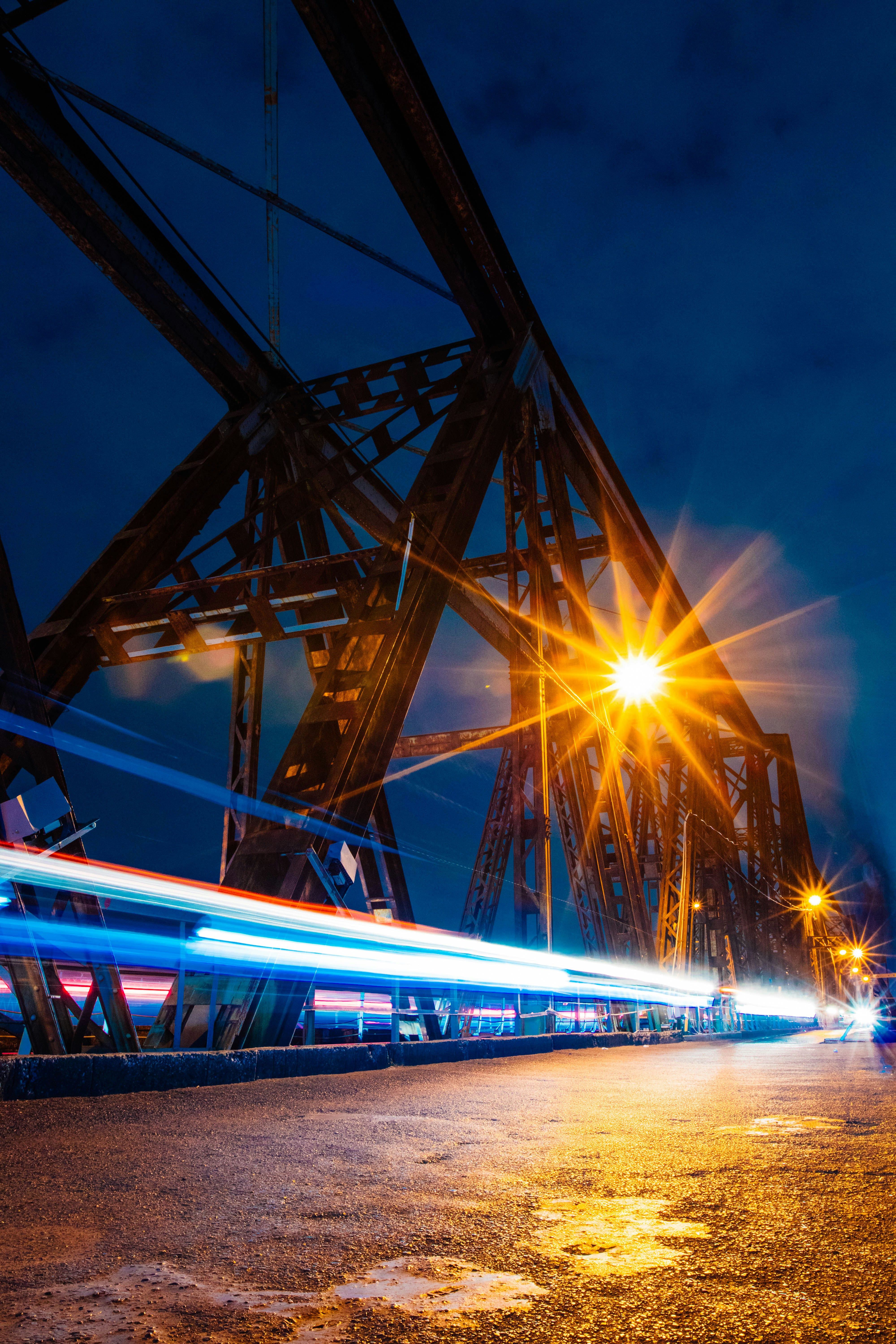 A train traveling over a bridge at night