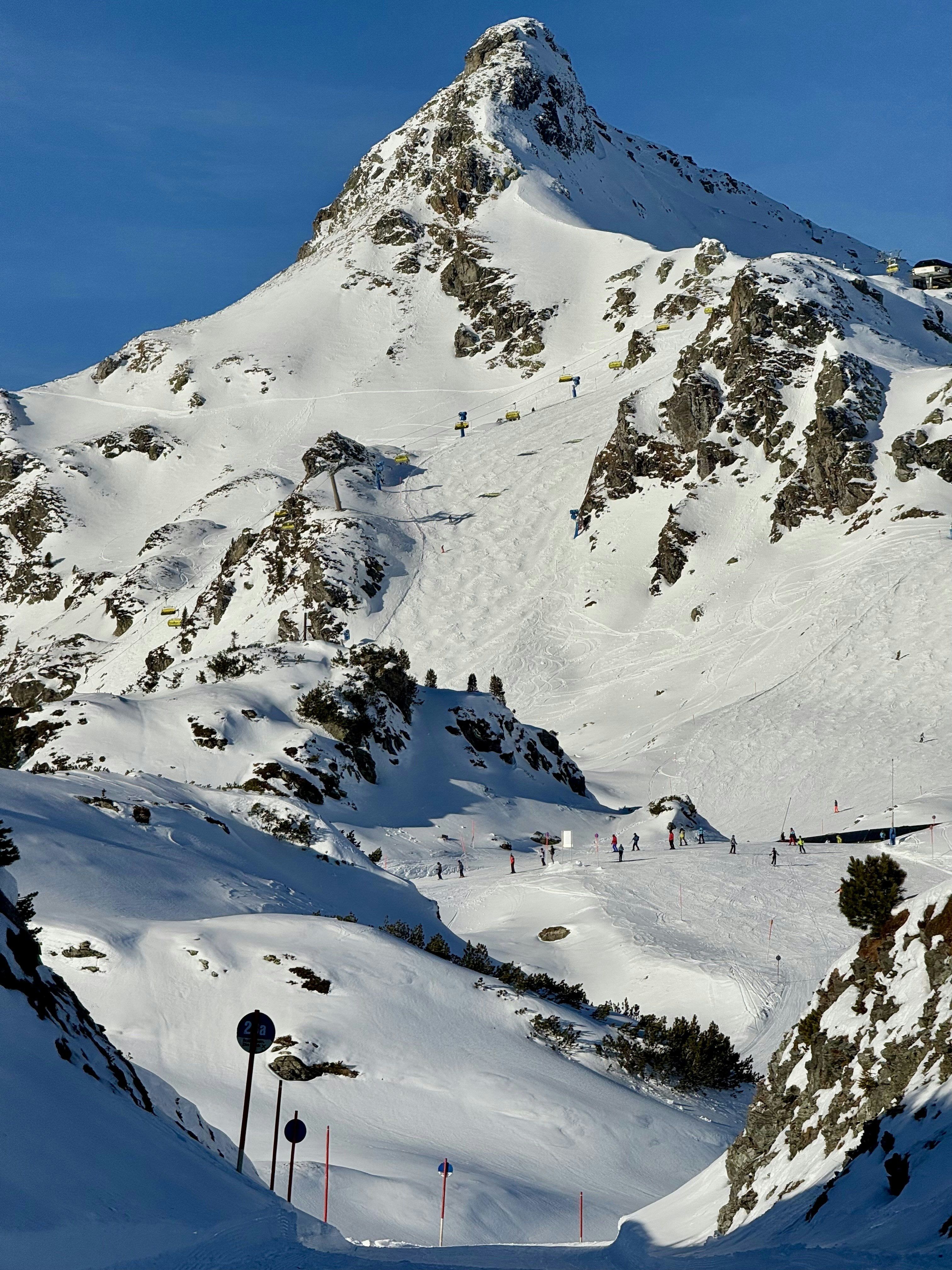 A snow covered mountain with a ski lift in the distance