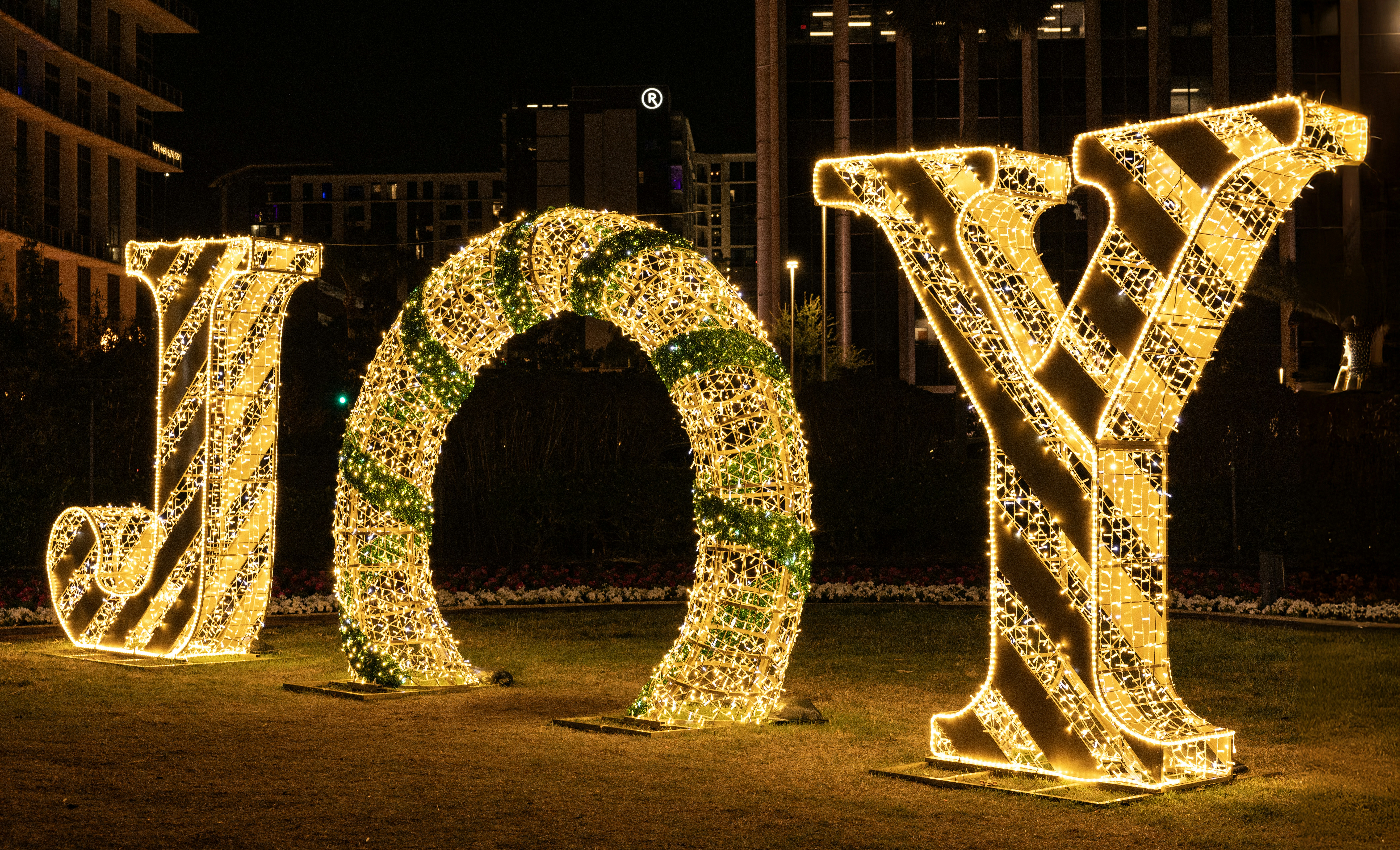 Lighted letters spelling joy in a park at night