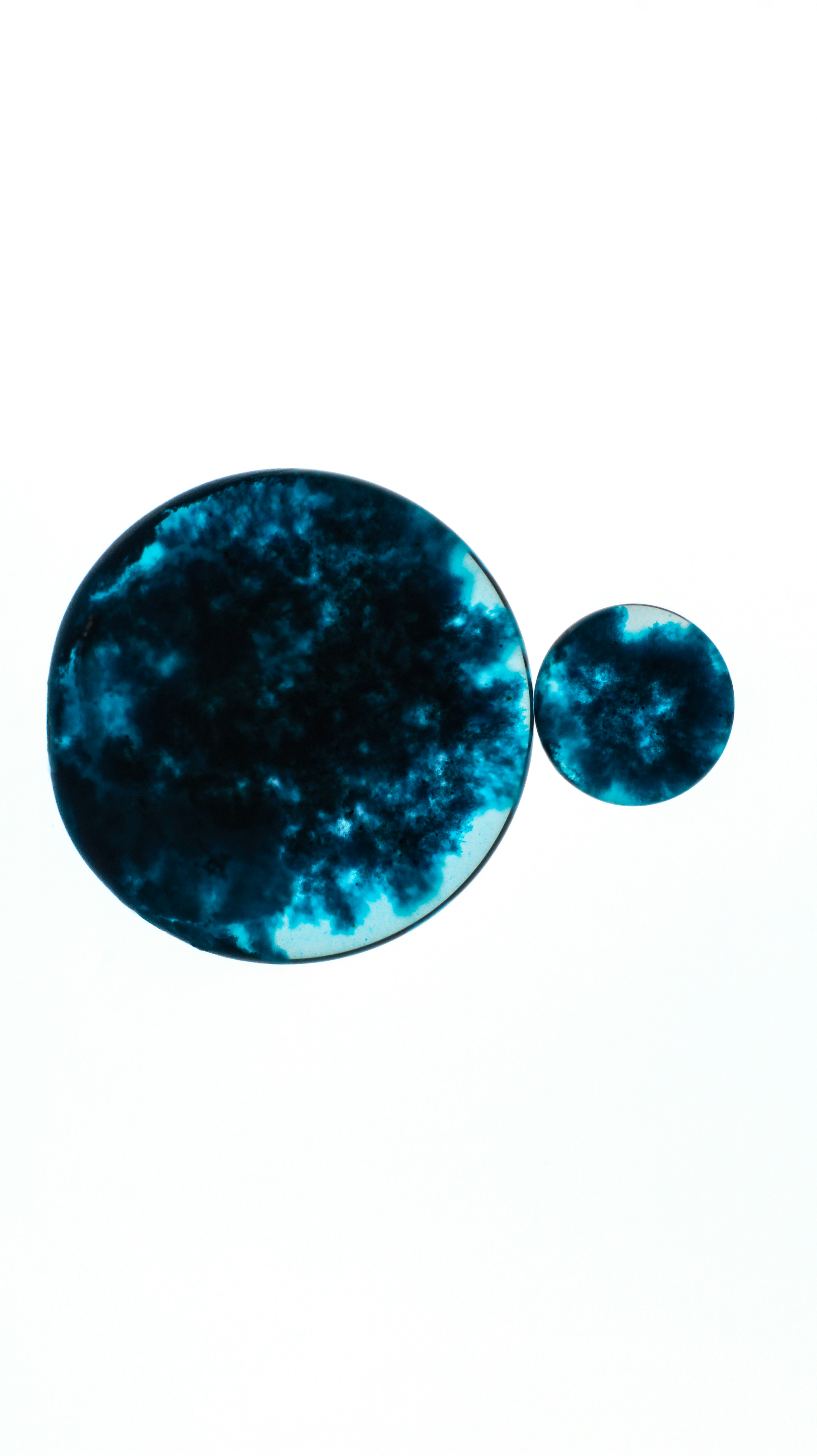 A pair of blue marbles on a white background