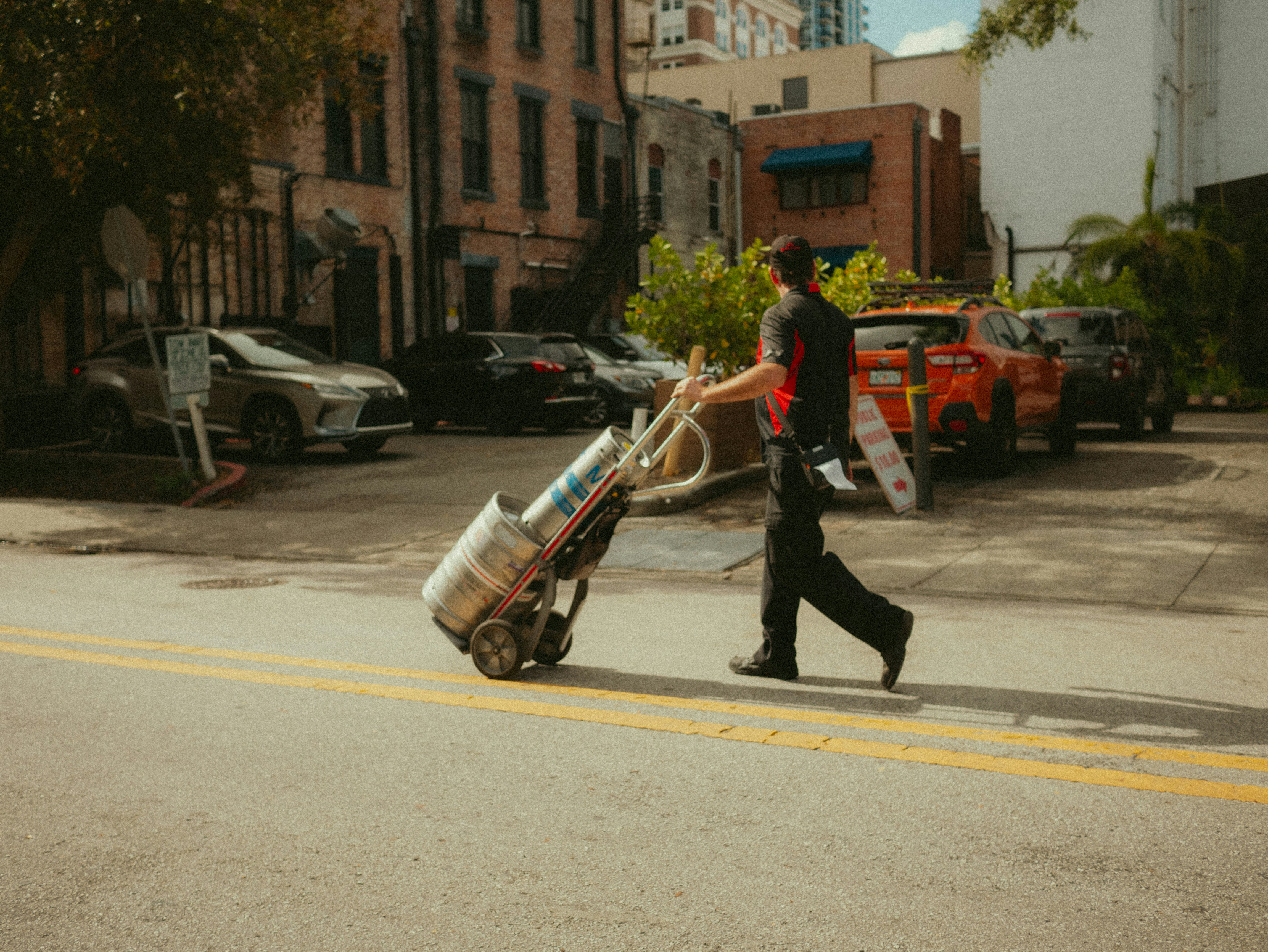 A man walking down the street with a large bag of luggage