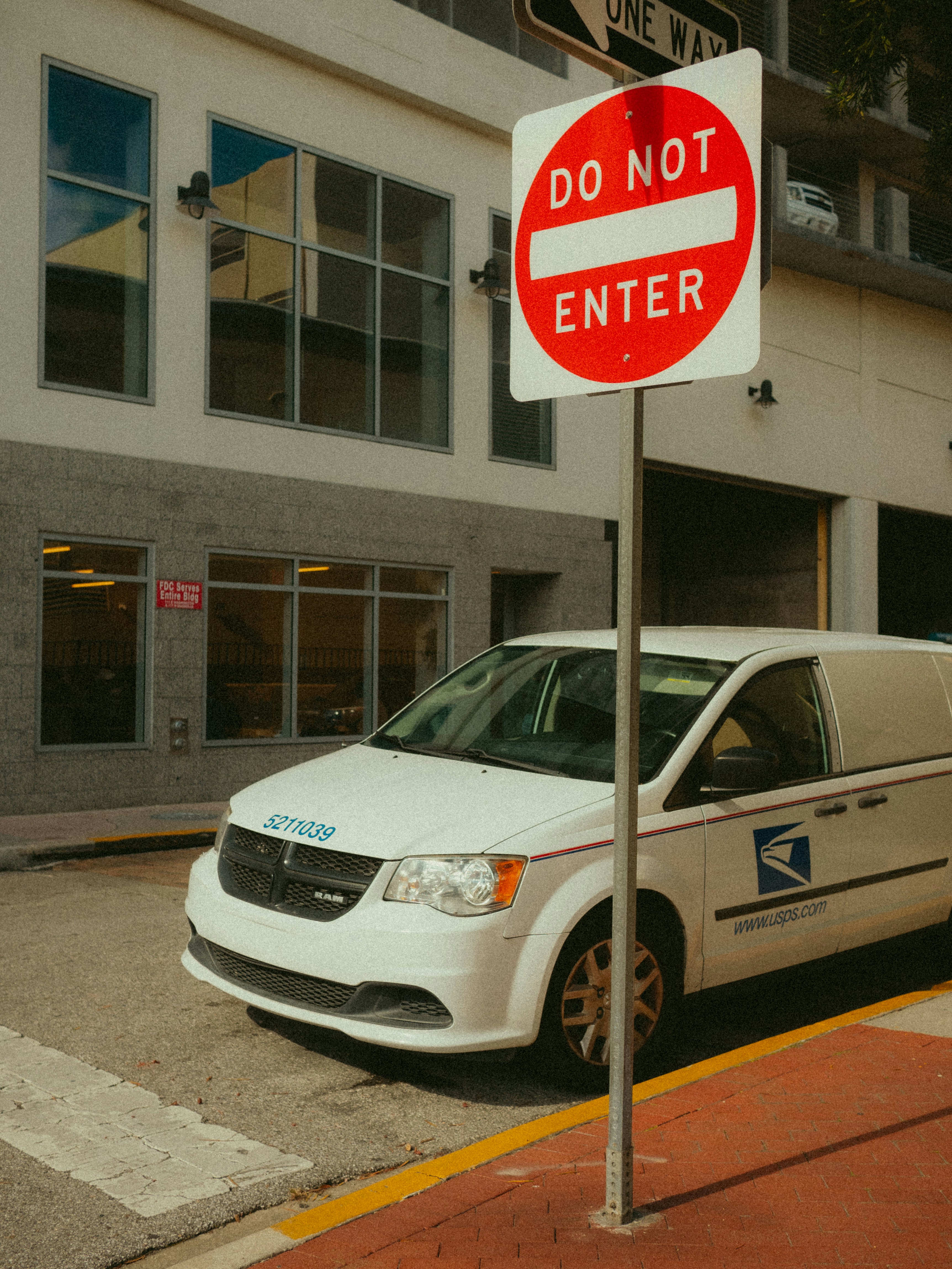 A white van parked next to a do not enter sign