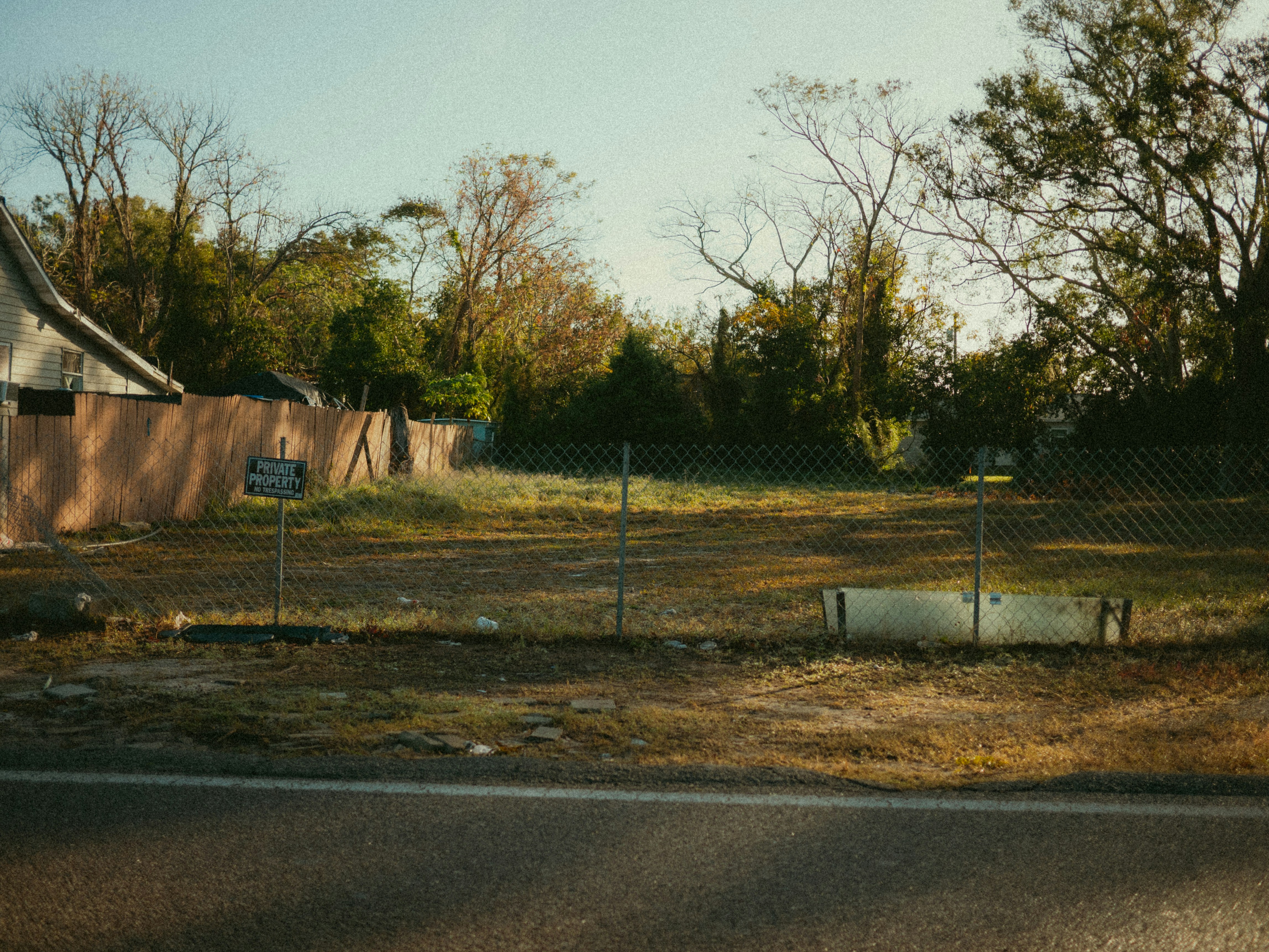 An empty lot next to a fence and trees