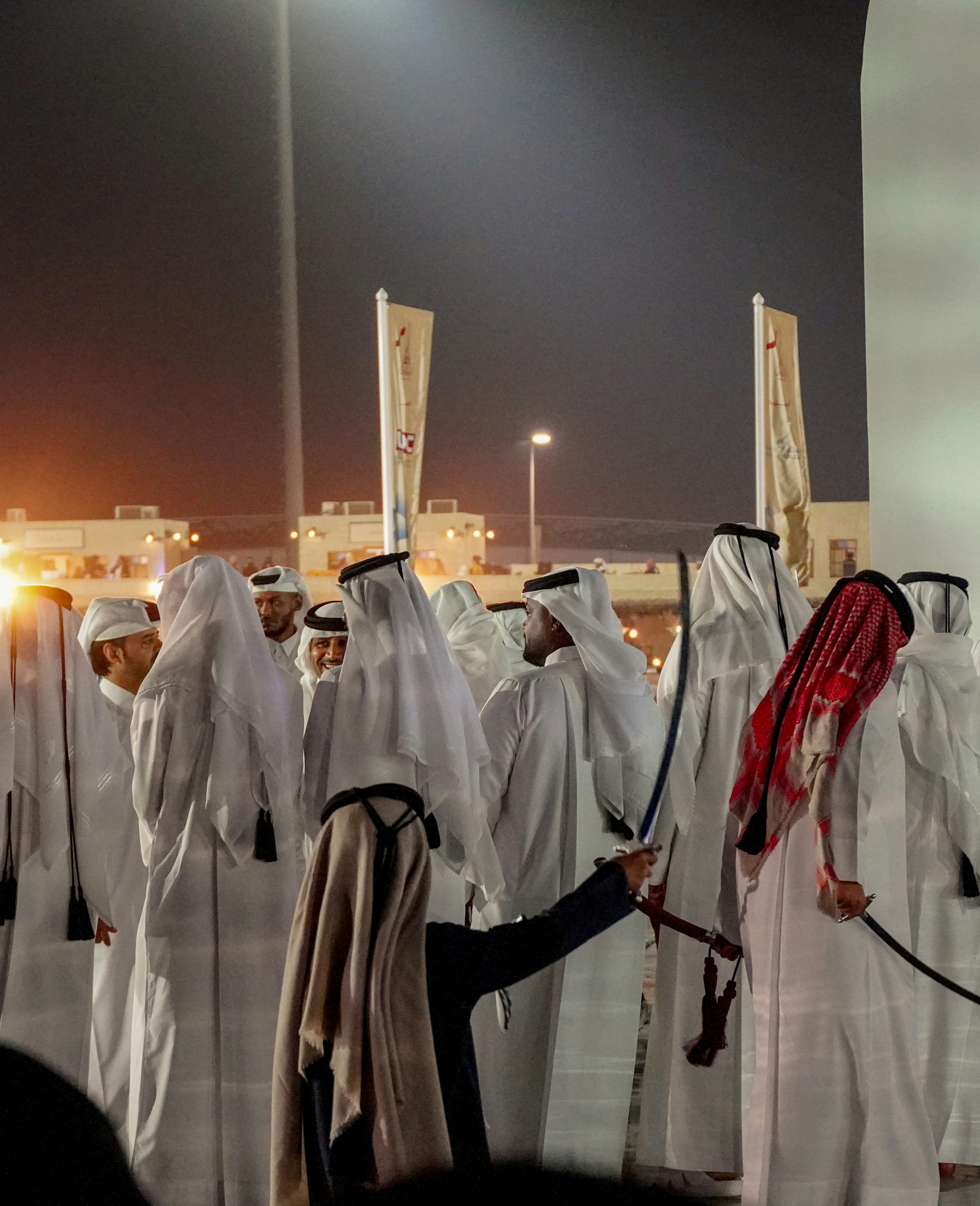 A group of men dressed in white standing next to each other