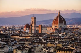 A view of a city with a dome and mountains in the background