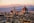 A view of a city with a dome and mountains in the background