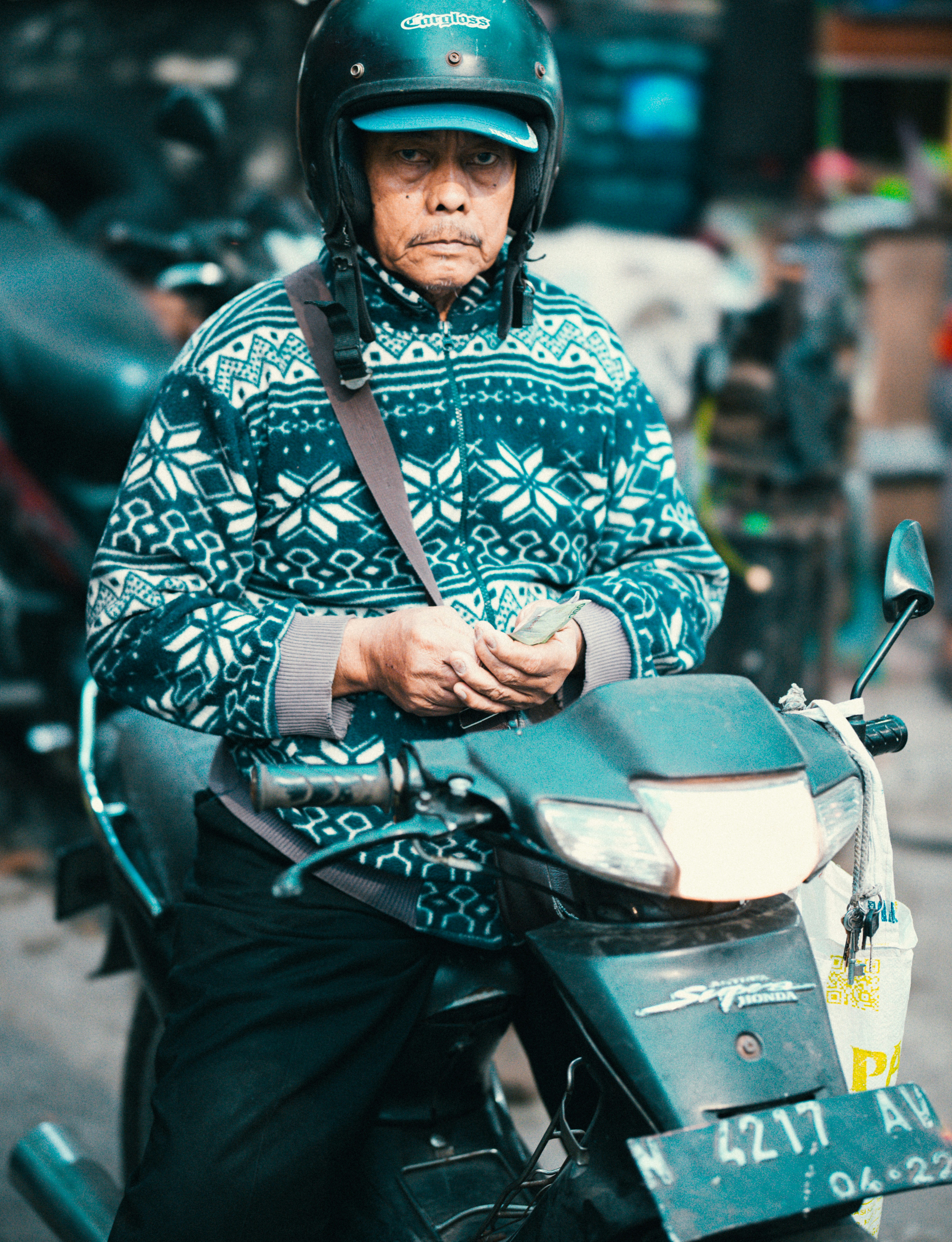 Seorang pria mengendarai sepeda motor di jalan