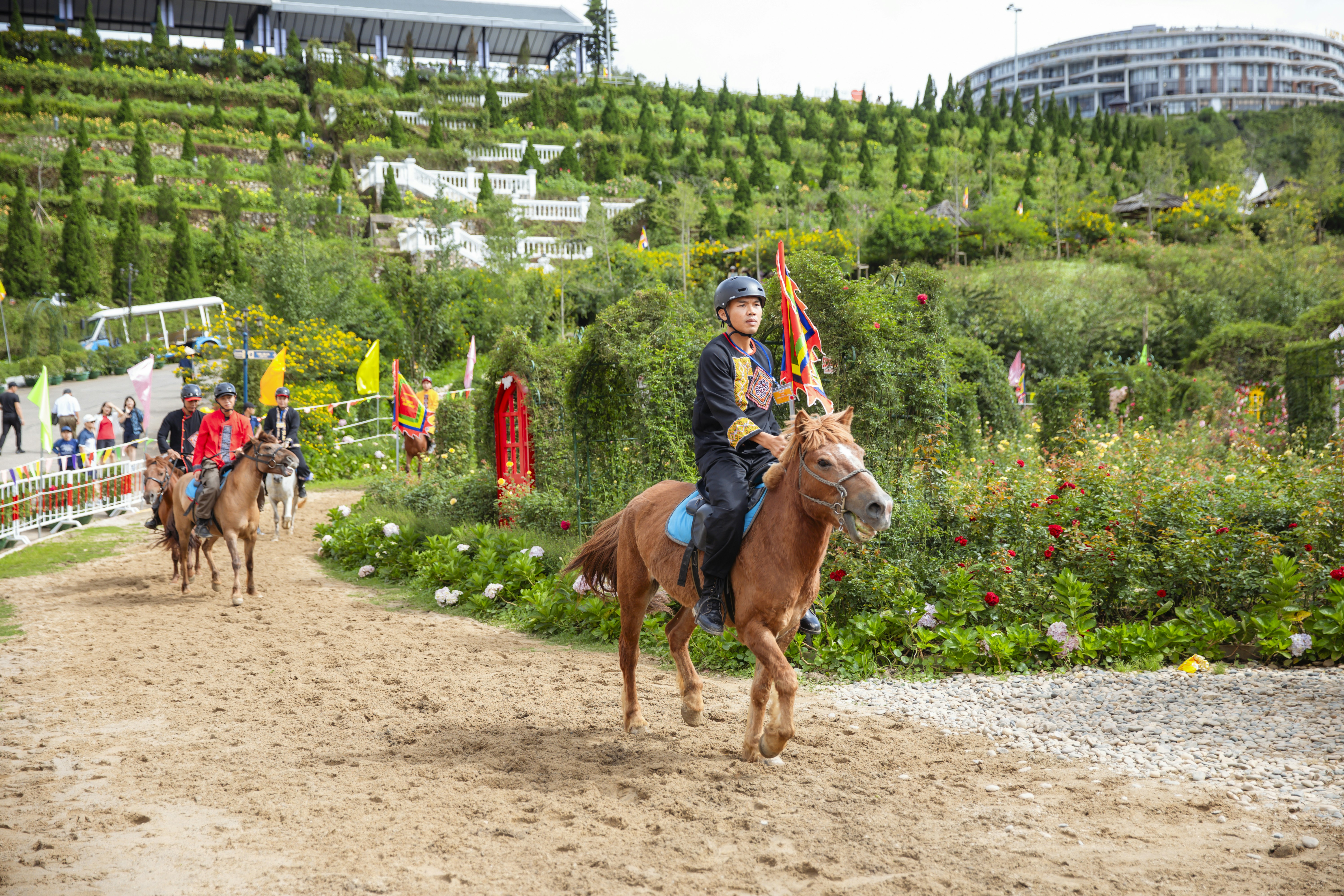 A group of people riding horses down a dirt road