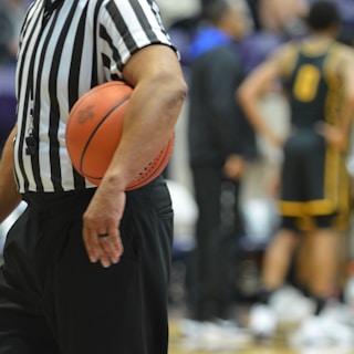 A referee holding a basketball on a basketball court