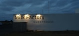 A sign that reads milk factory in front of a building