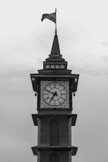 A clock tower with a flag on top of it
