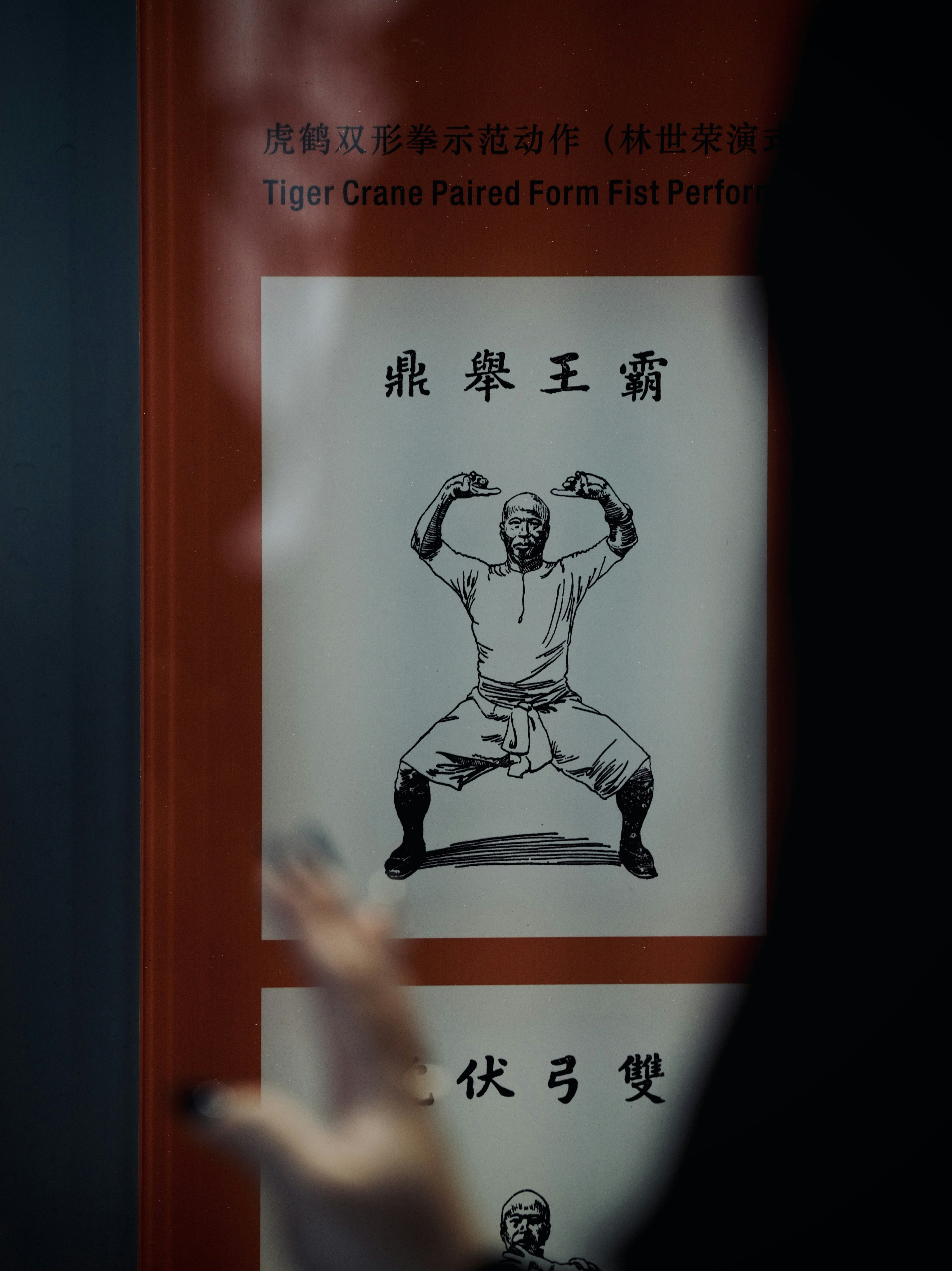 A person holding their hand up in front of a sign