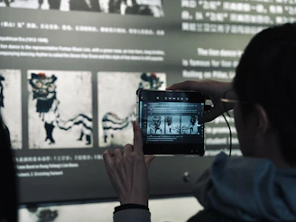 A woman taking a picture of a movie on her phone