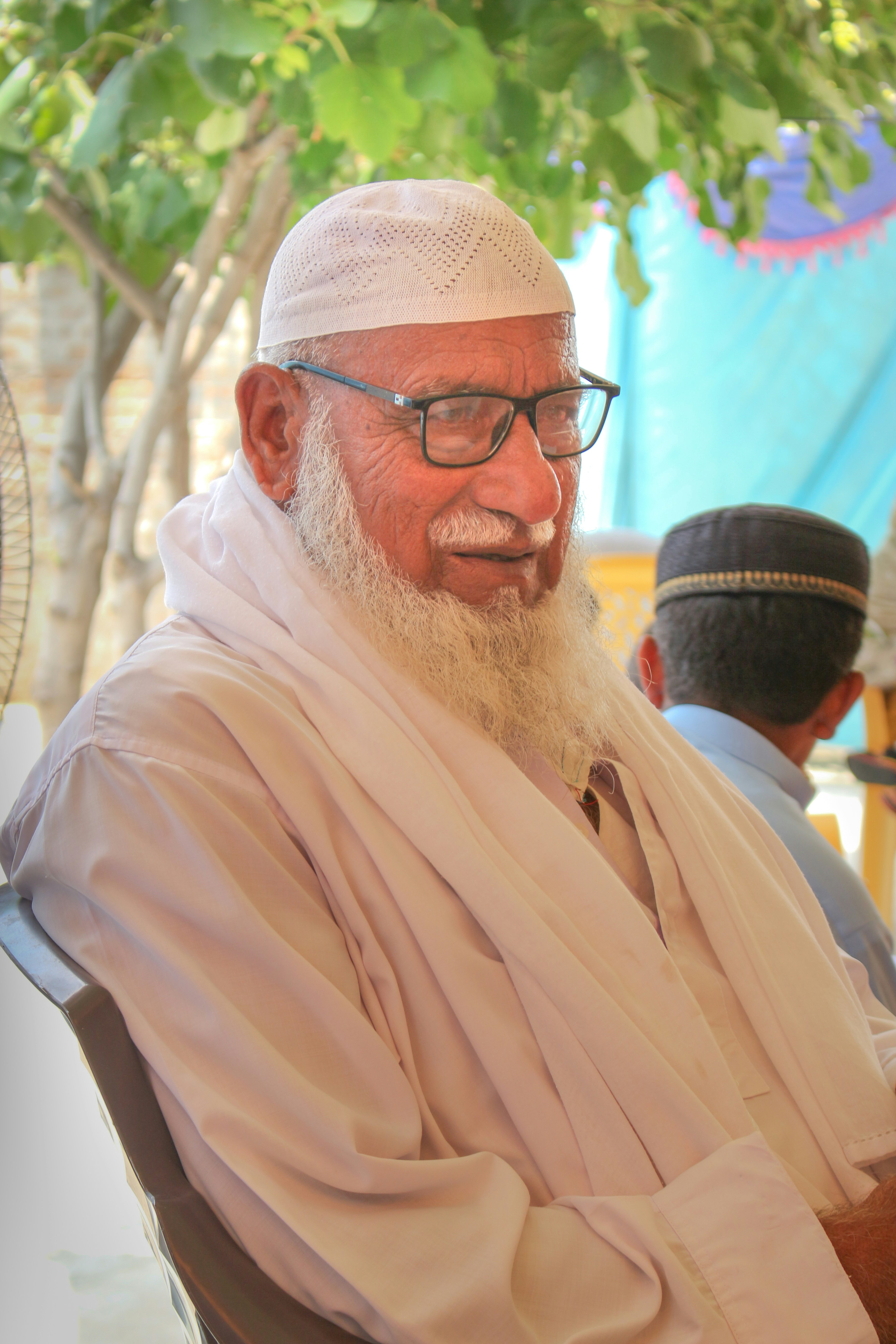 A man with a white beard sitting in a chair