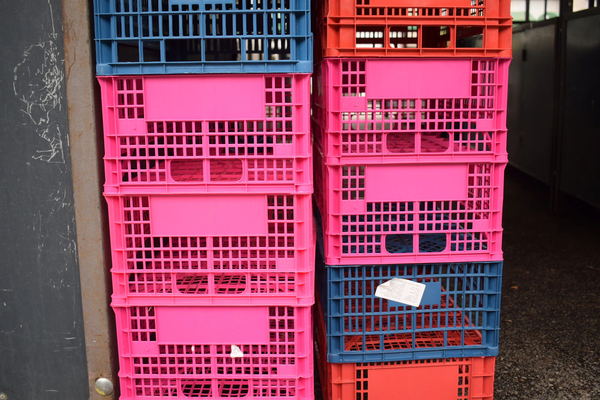 A stack of pink and blue crates sitting next to each other