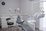 A dental room with a chair and a desk